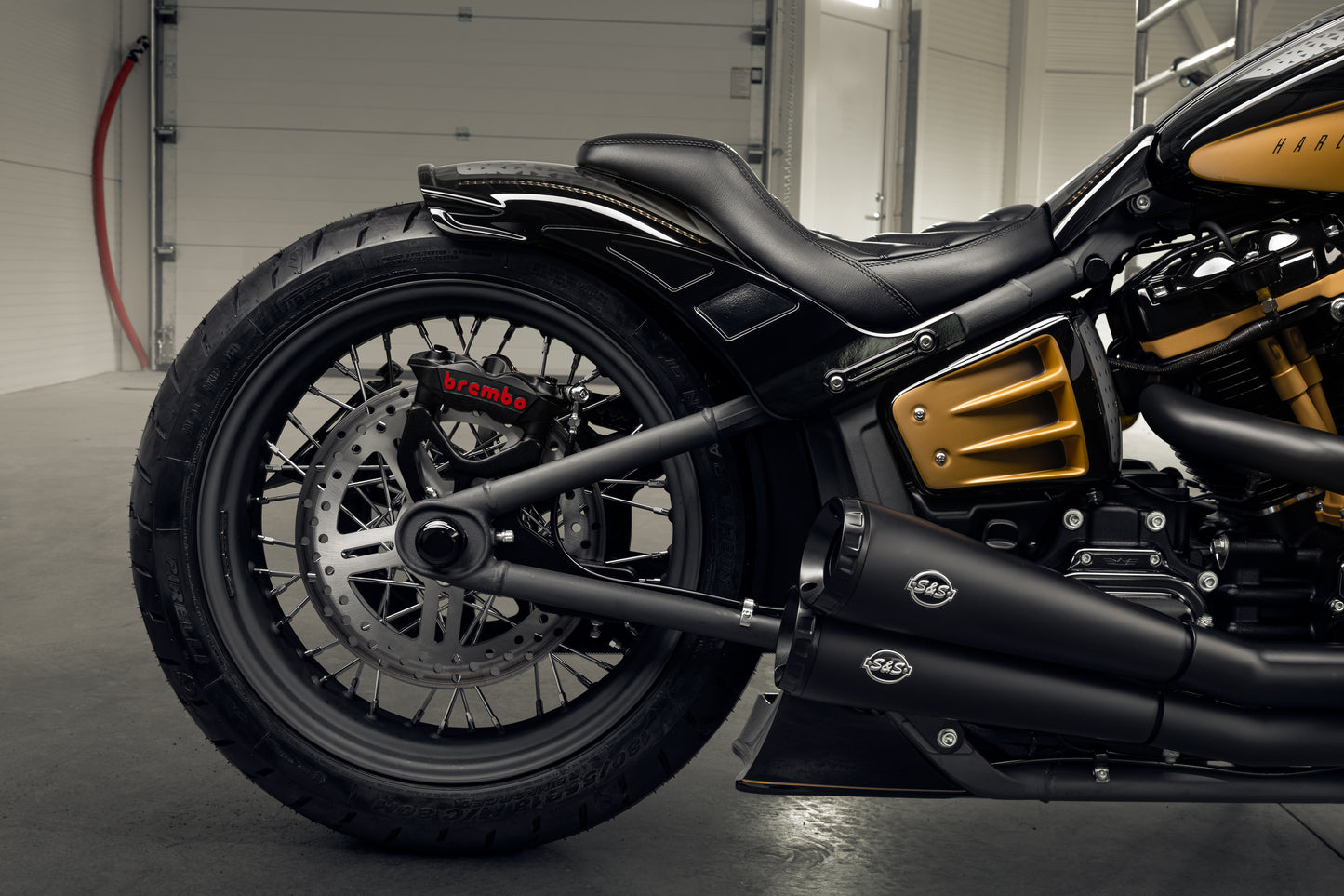 Harley Davidson motorcycle with Killer Custom "Rodstr" rear fender from the side in a modern garage