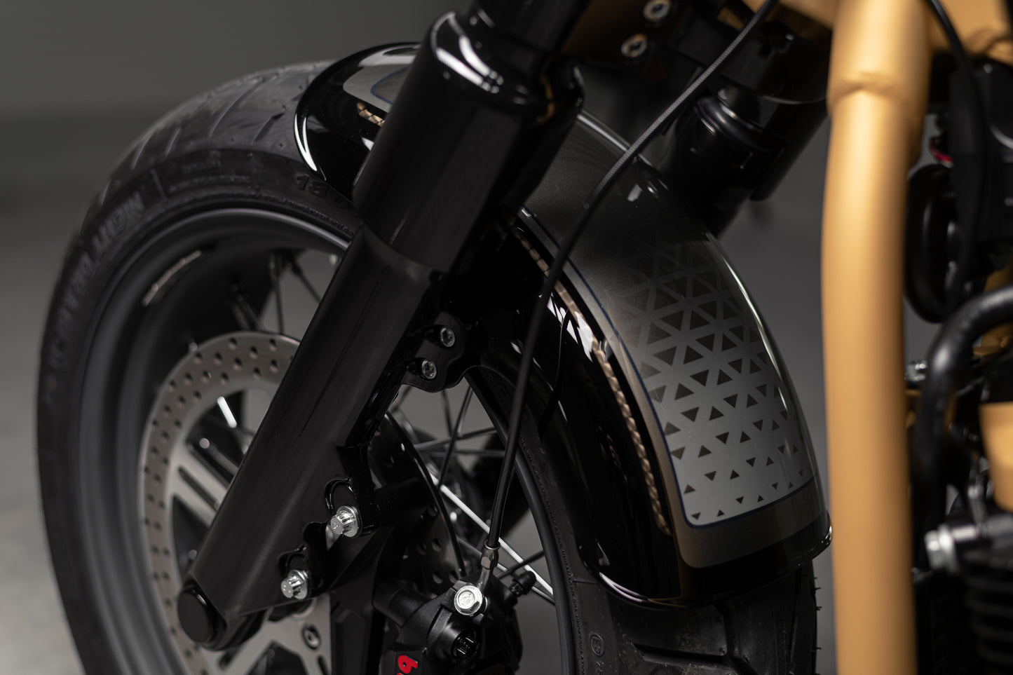 Zoomed Harley Davidson motorcycle with Killer Custom front wide wheel fender grey background