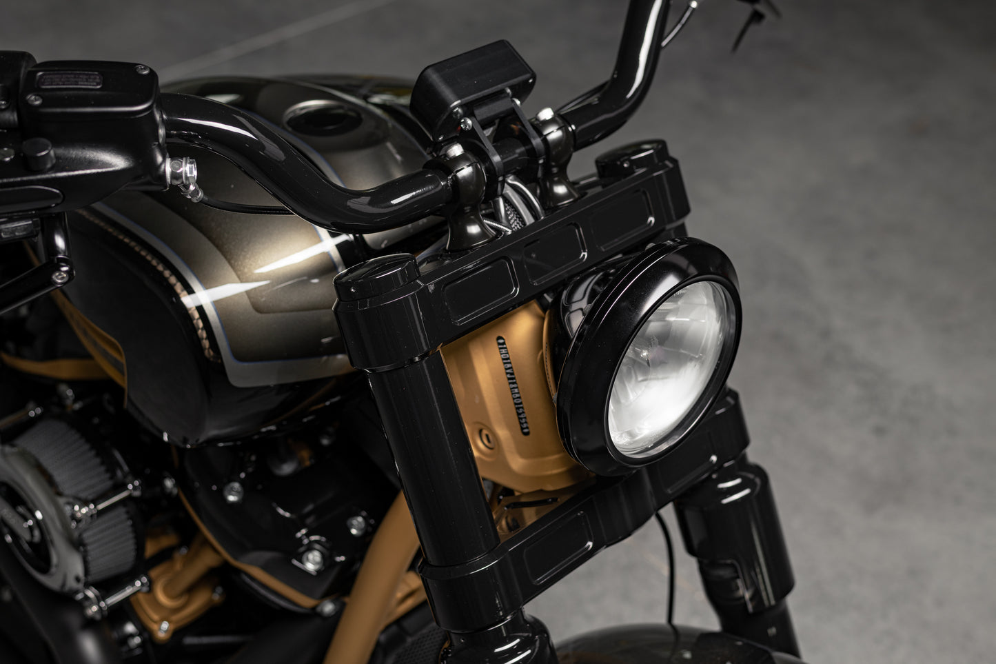 Zoomed Harley Davidson motorcycle with Killer Custom wide triple trees set from the front grey background