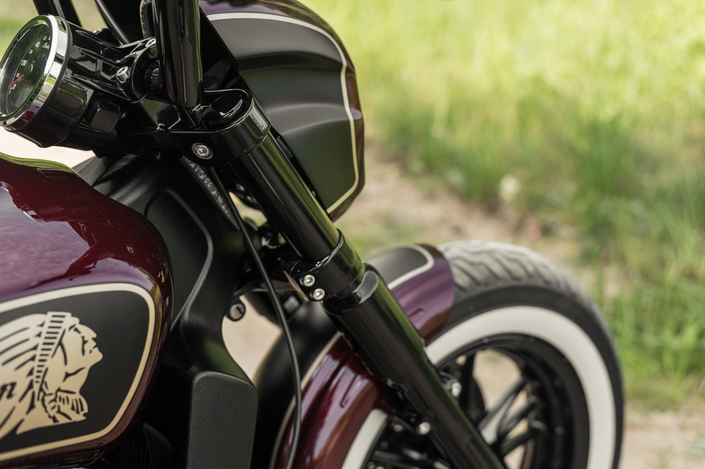 Zoomed Harley Davidson motorcycle with Killer Custom "Tomahawk" full fork covers set green blurry background