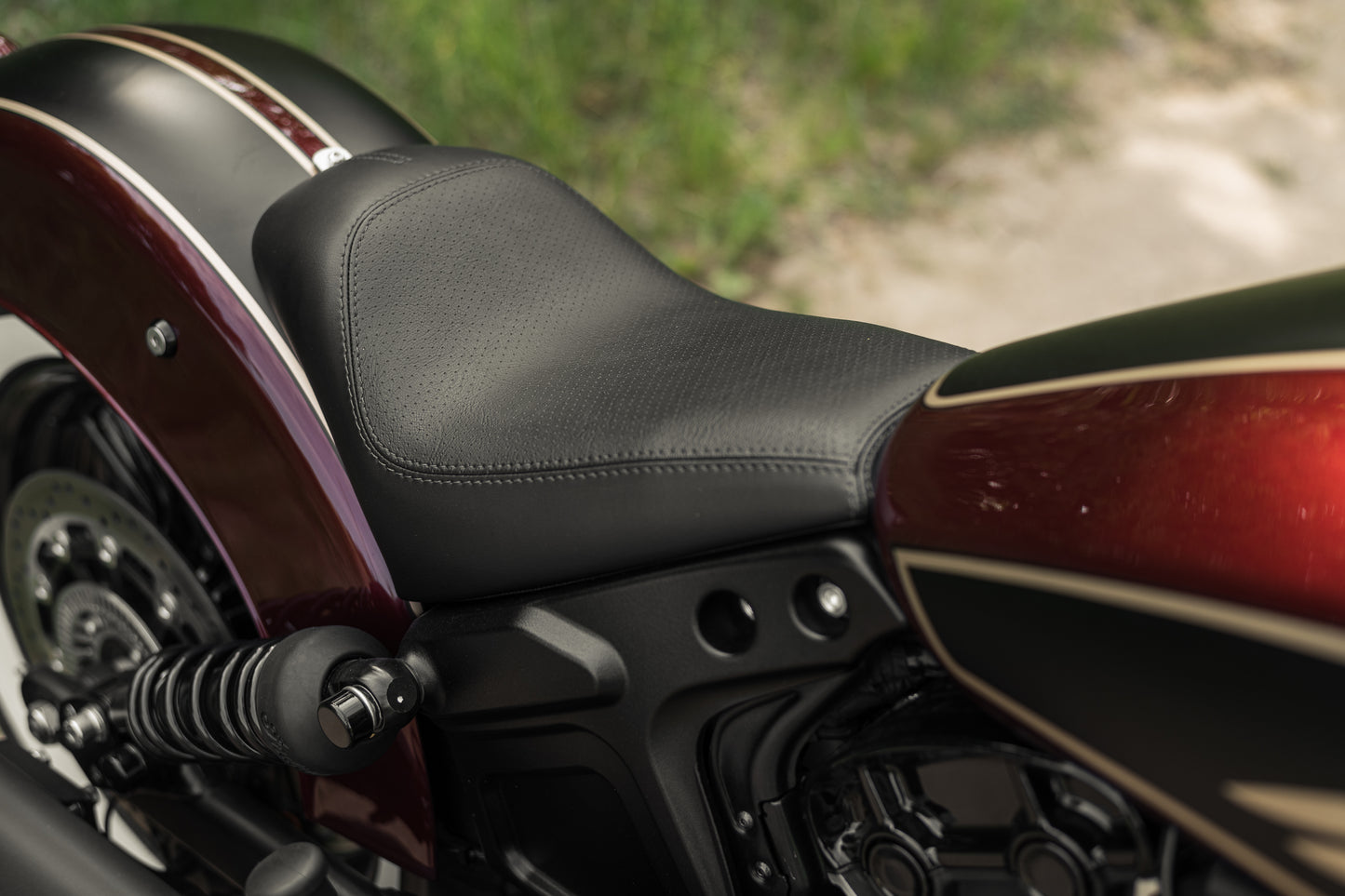 Zoomed Harley Davidson motorcycle with Killer Custom  rear shock bolt covers on a roadside blurry background