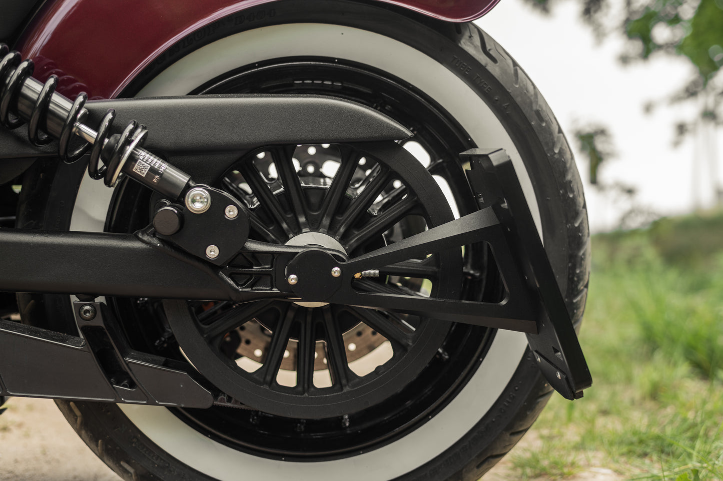 Zoomed Harley Davidson motorcycle with Killer Custom license plate bracket from the side with blurred grass in the background