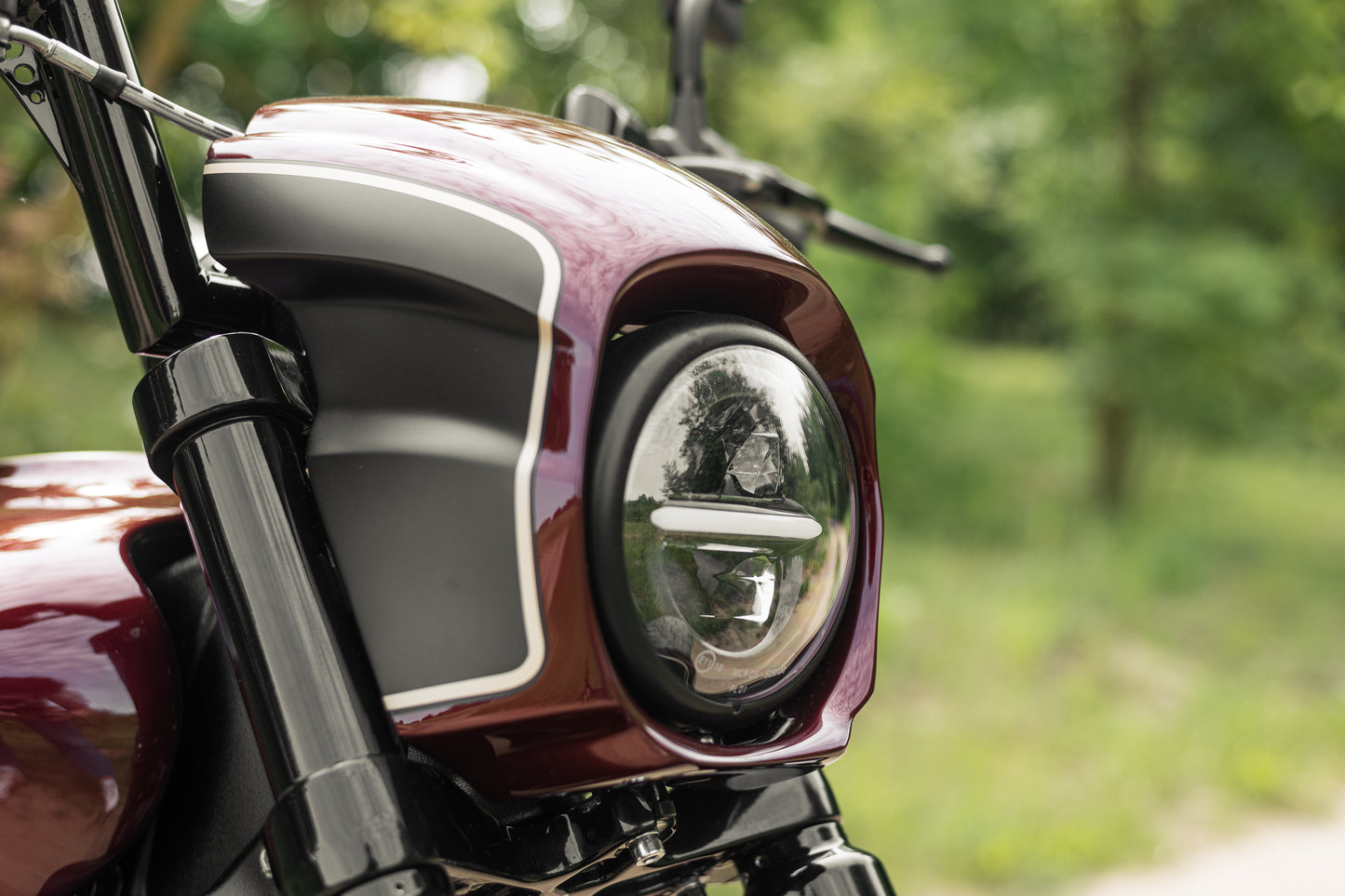 Harley Davidson motorcycle with Killer Custom "Tomahawk" series headlight fairing from the side, blurry green background