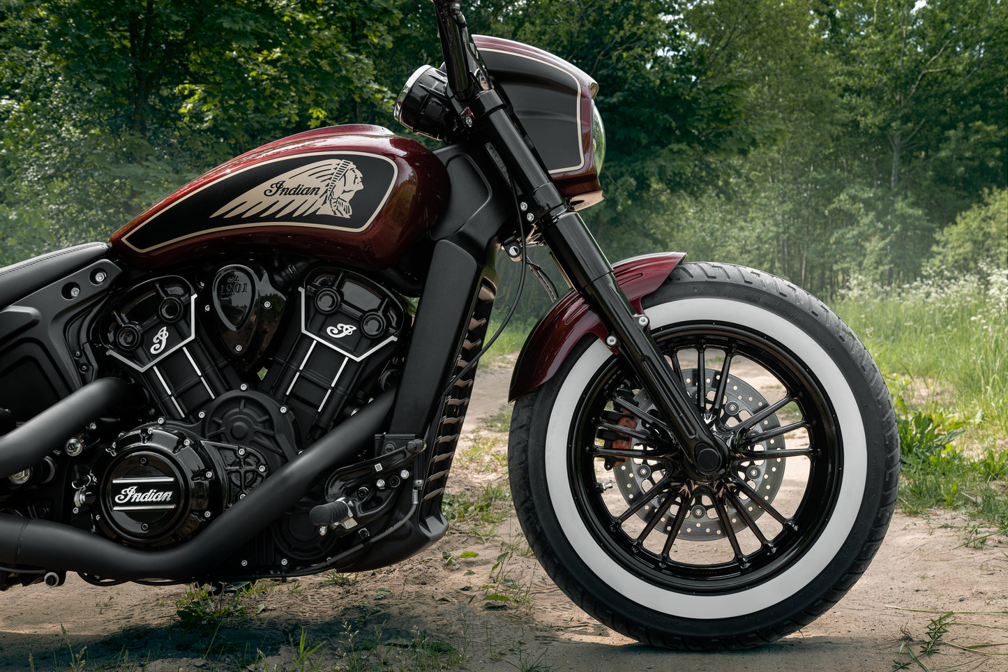 Harley Davidson motorcycle with Killer Custom "Tomahawk" series front fender from the side in the forest on a sunny day