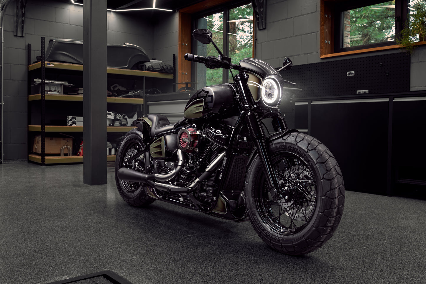 Harley Davidson motorcycle with Killer Custom "Aggressor" full fork cover set from the front in a modern bike shop with some equipment in the background