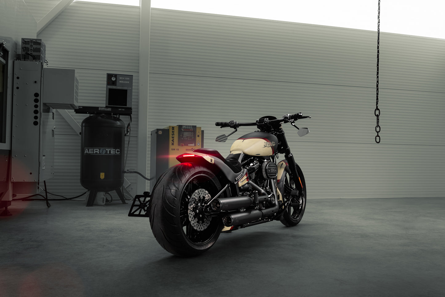 Harley Davidson motorcycle with Killer Custom "Avenger" rear fender kit from the rear in a spacious modern garage