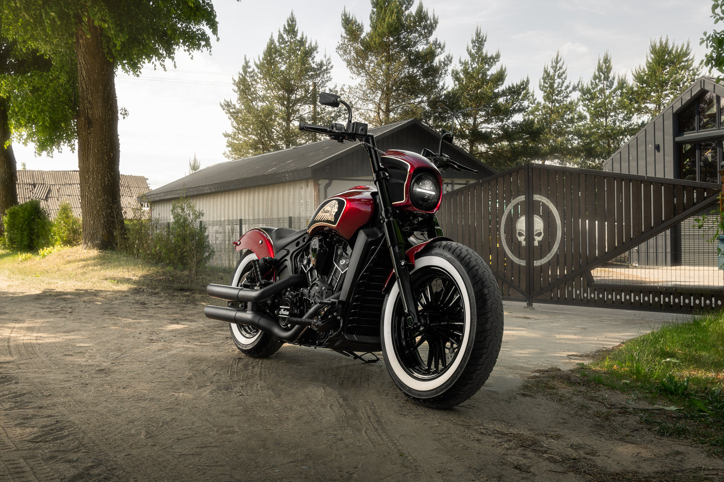 Harley Davidson motorcycle with Killer Custom "Tomahawk" full fork covers set from the front with a fence and a few buildings in the background