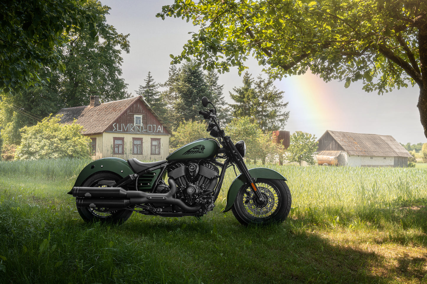 Harley Davidson motorcycle with Killer Custom bobber fork caps on a countryside with a few houses and some trees in the background