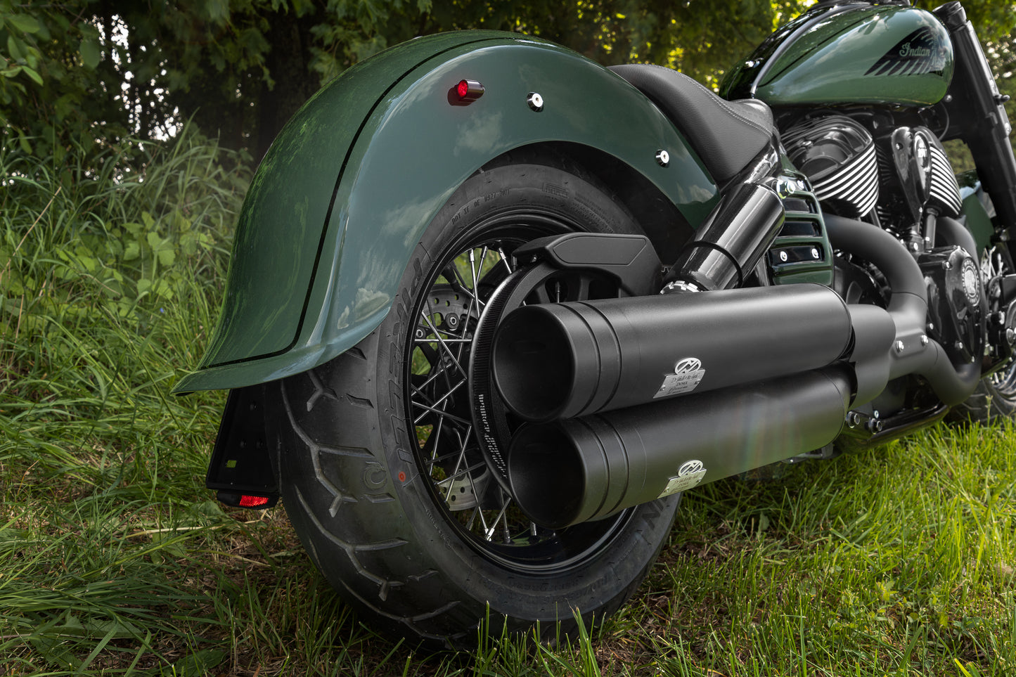 Harley Davidson motorcycle with Killer Custom "Apache" rear fender from the rear in the forest on a sunny day