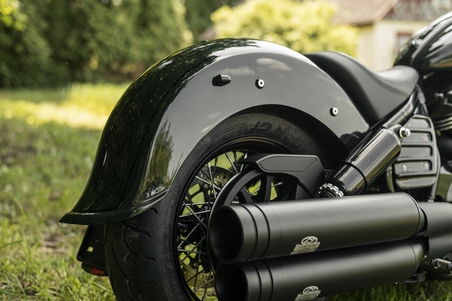 Zoomed Harley Davidson motorcycle with Killer Custom "Apache" rear fender from the rear on the countryside