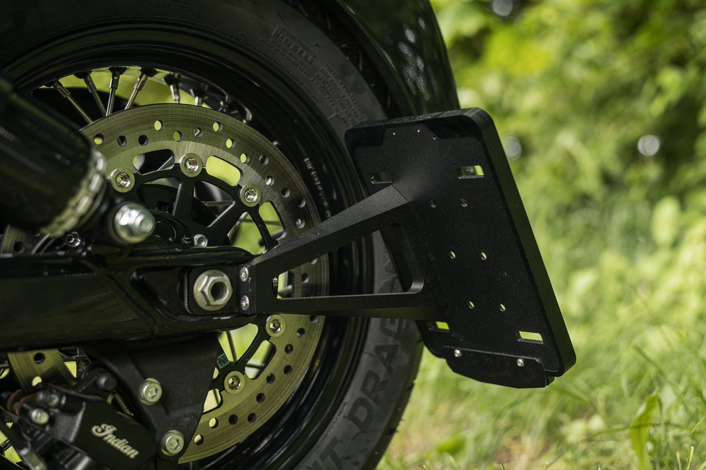 Zoomed Harley Davidson motorcycle with Killer Custom  license plate bracket green blurry background