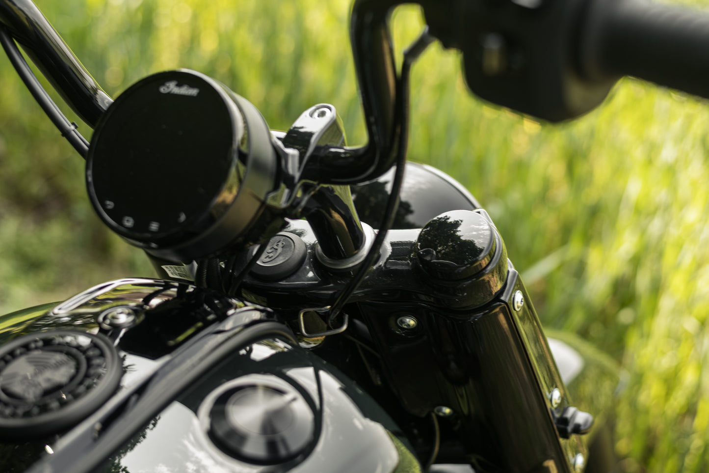 Zoomed Harley Davidson motorcycle with Killer Custom parts from above green blurry background