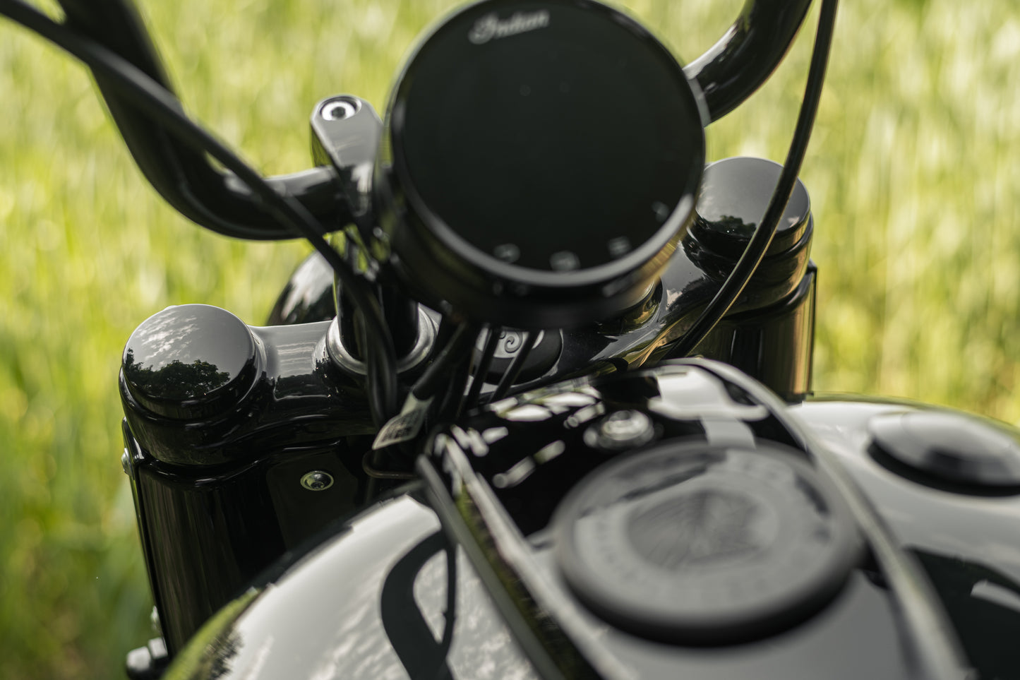 Zoomed  Harley Davidson motorcycle with Killer Custom bobber fork caps green blurry background