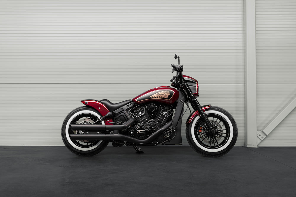 Harley Davidson motorcycle with Killer Custom Indian scout solo seat from the side in a modern garage