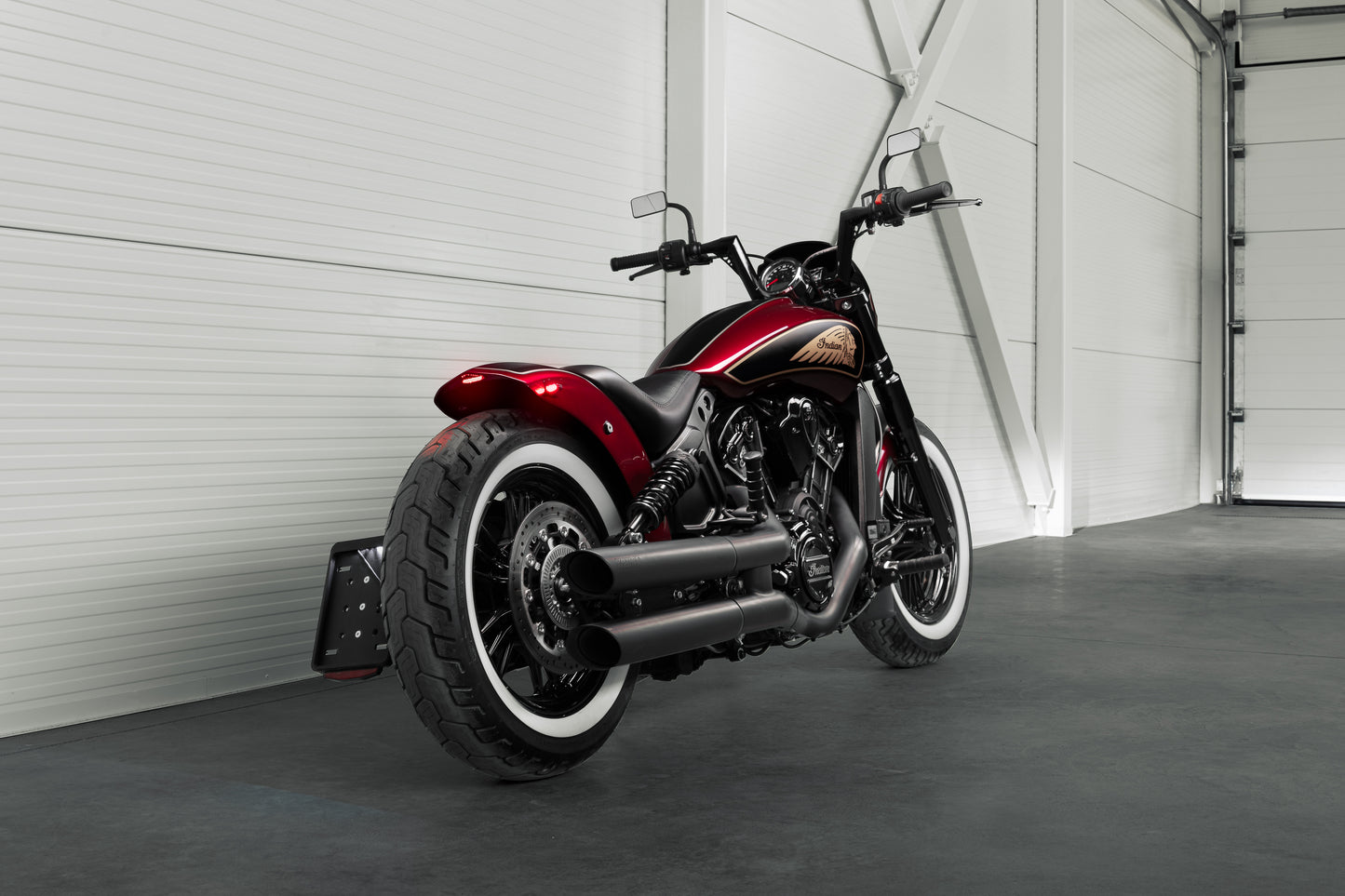 Harley Davidson motorcycle with Killer Custom "Tomahawk" rear fender from the rear in a modern white garage
