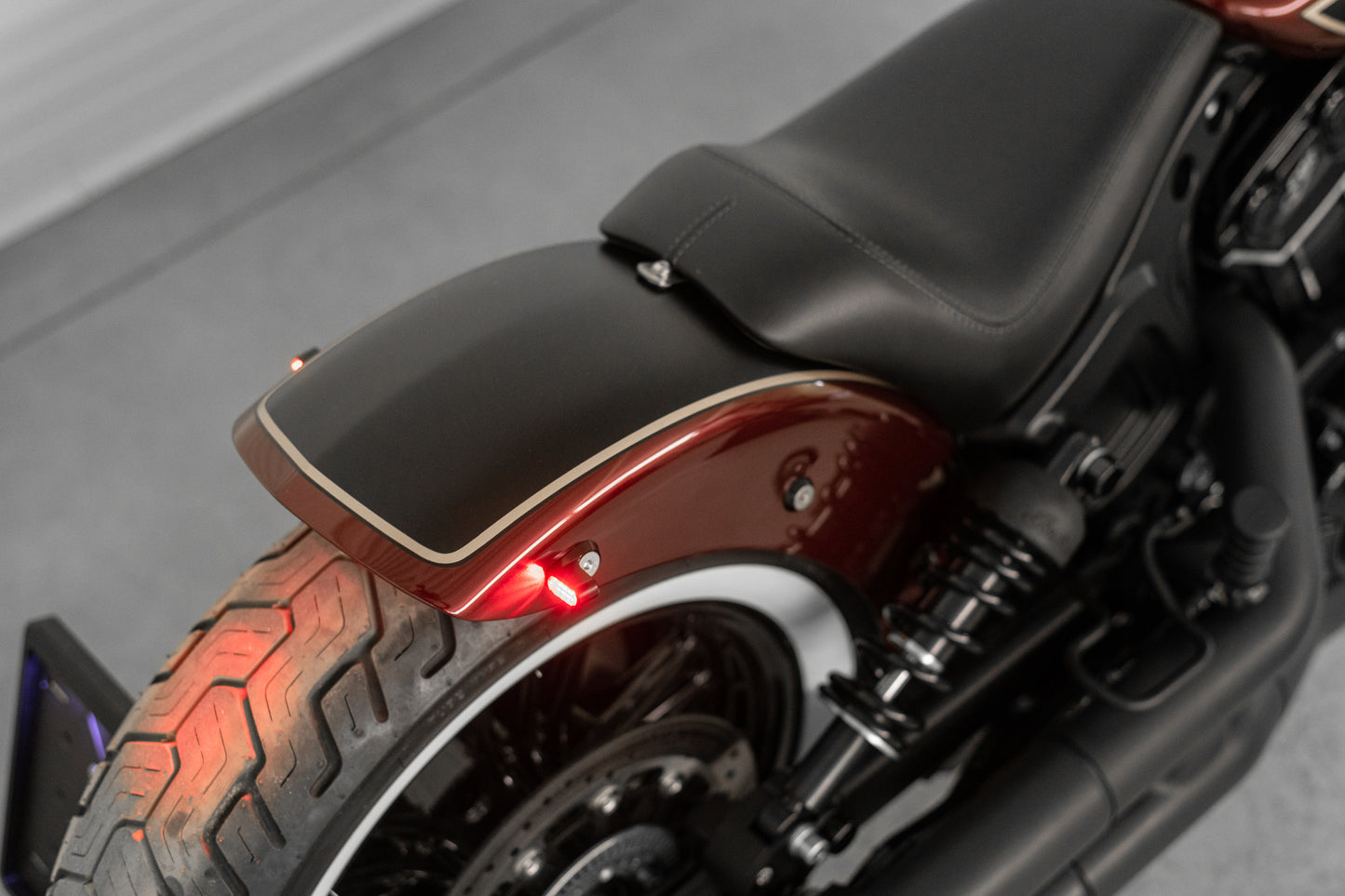Zoomed Harley Davidson motorcycle with Killer Custom "Tomahawk" rear fender from above grey background