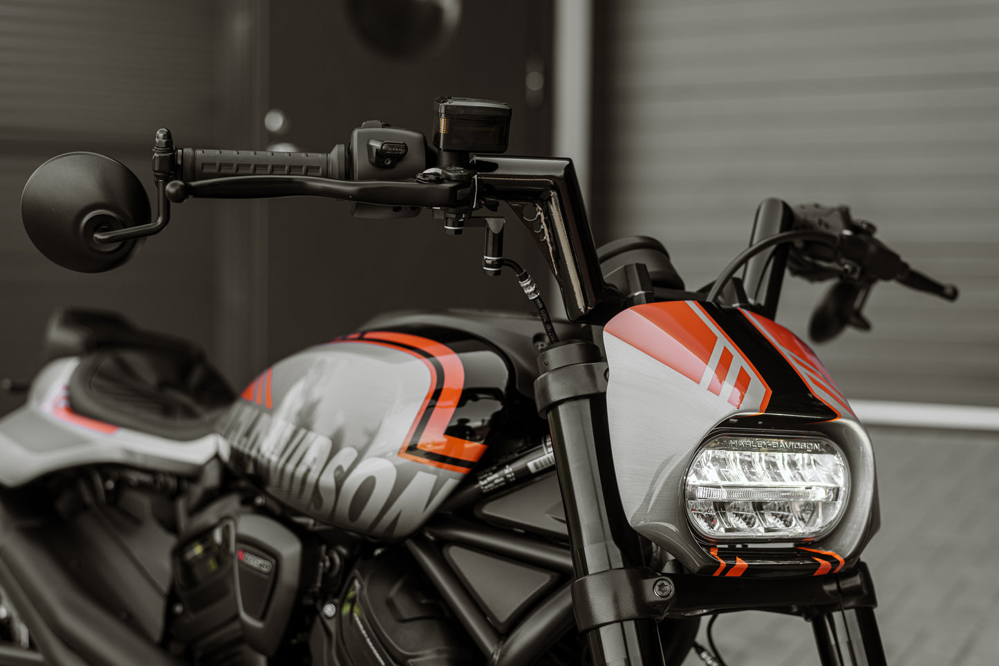 Harley Davidson motorcycle with Killer Custom hydraulic brake and clutch hoses extension from the front grey blurry background