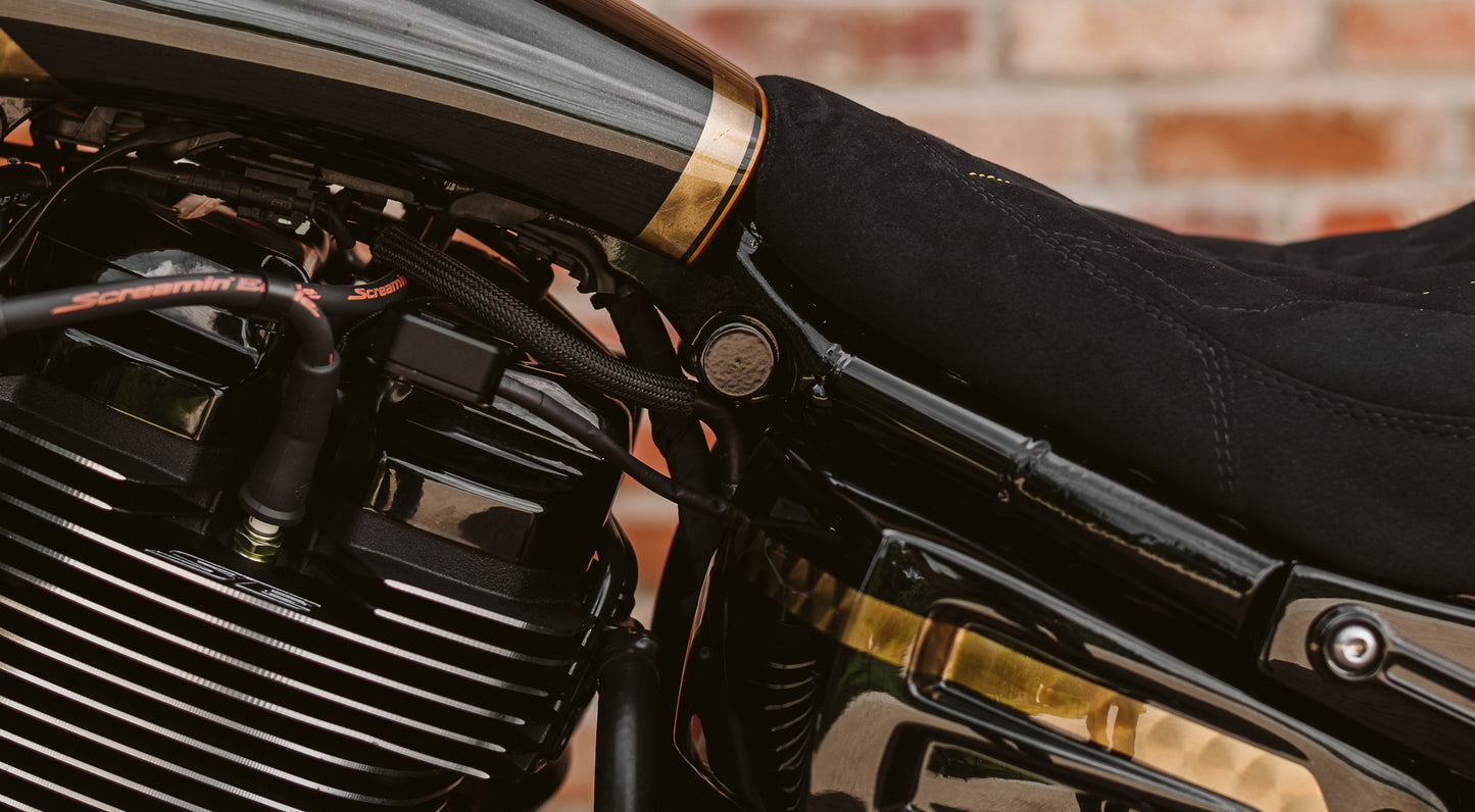 Zoomed Harley Davidson motorcycle with Killer Custom rear shock upper bolt covers from the side