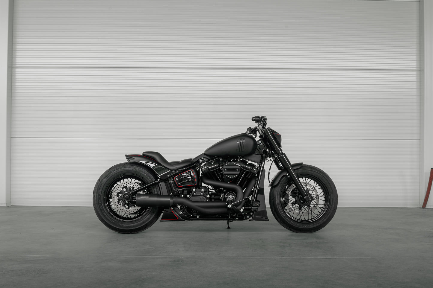 Harley Davidson motorcycle with Killer Custom wide triple trees set from the side in a spacious and modern garage