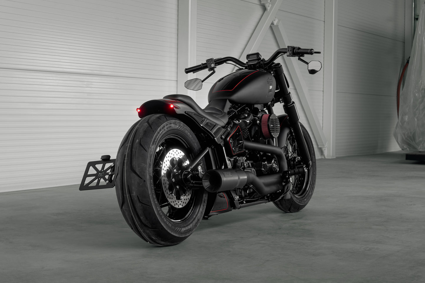 Harley Davidson motorcycle with Killer Custom "Rodstr" rear fender from the rear in a modern garage