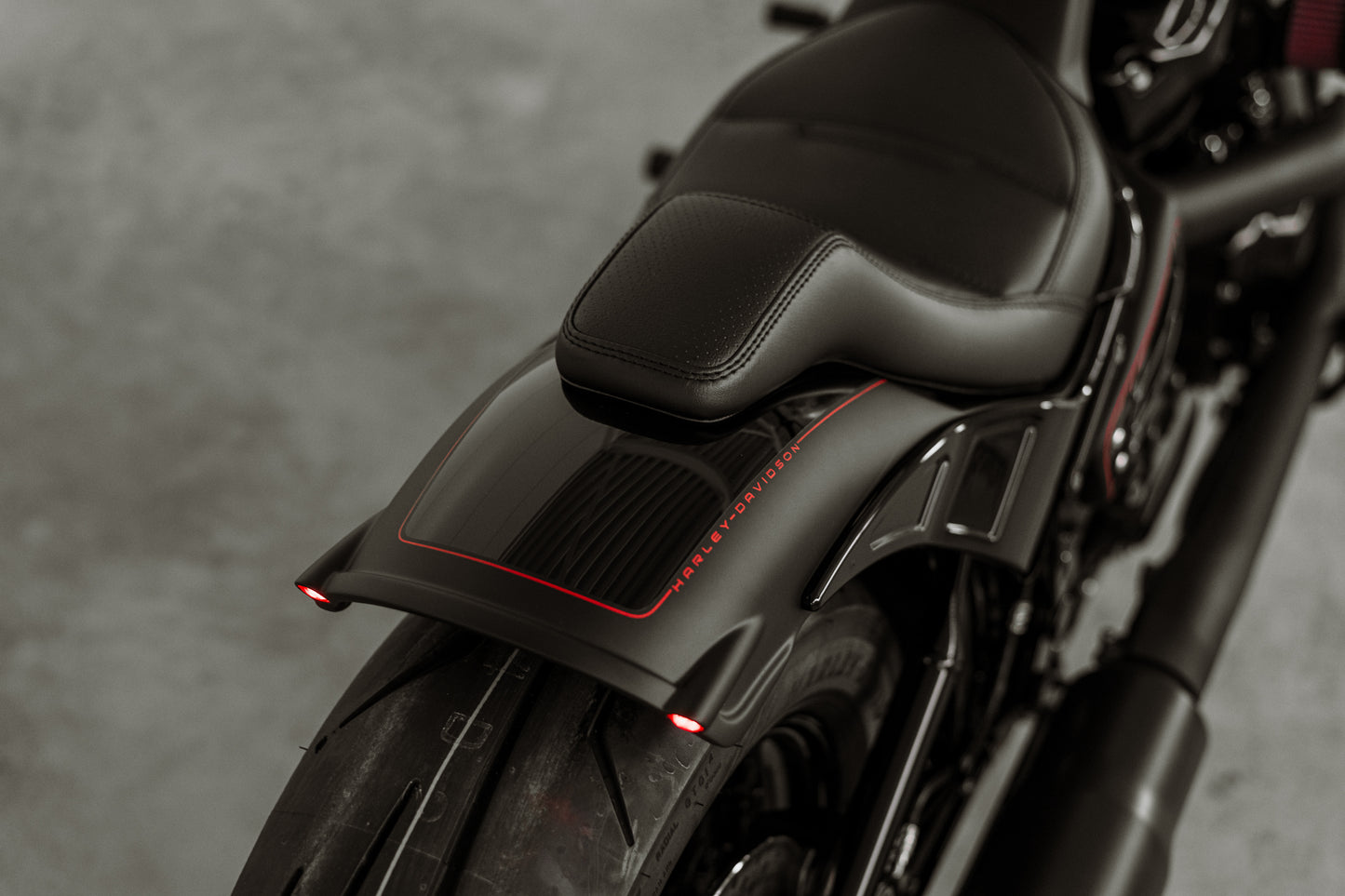 Zoomed Harley Davidson motorcycle with Killer Custom "Rodstr" rear fender from above grey background