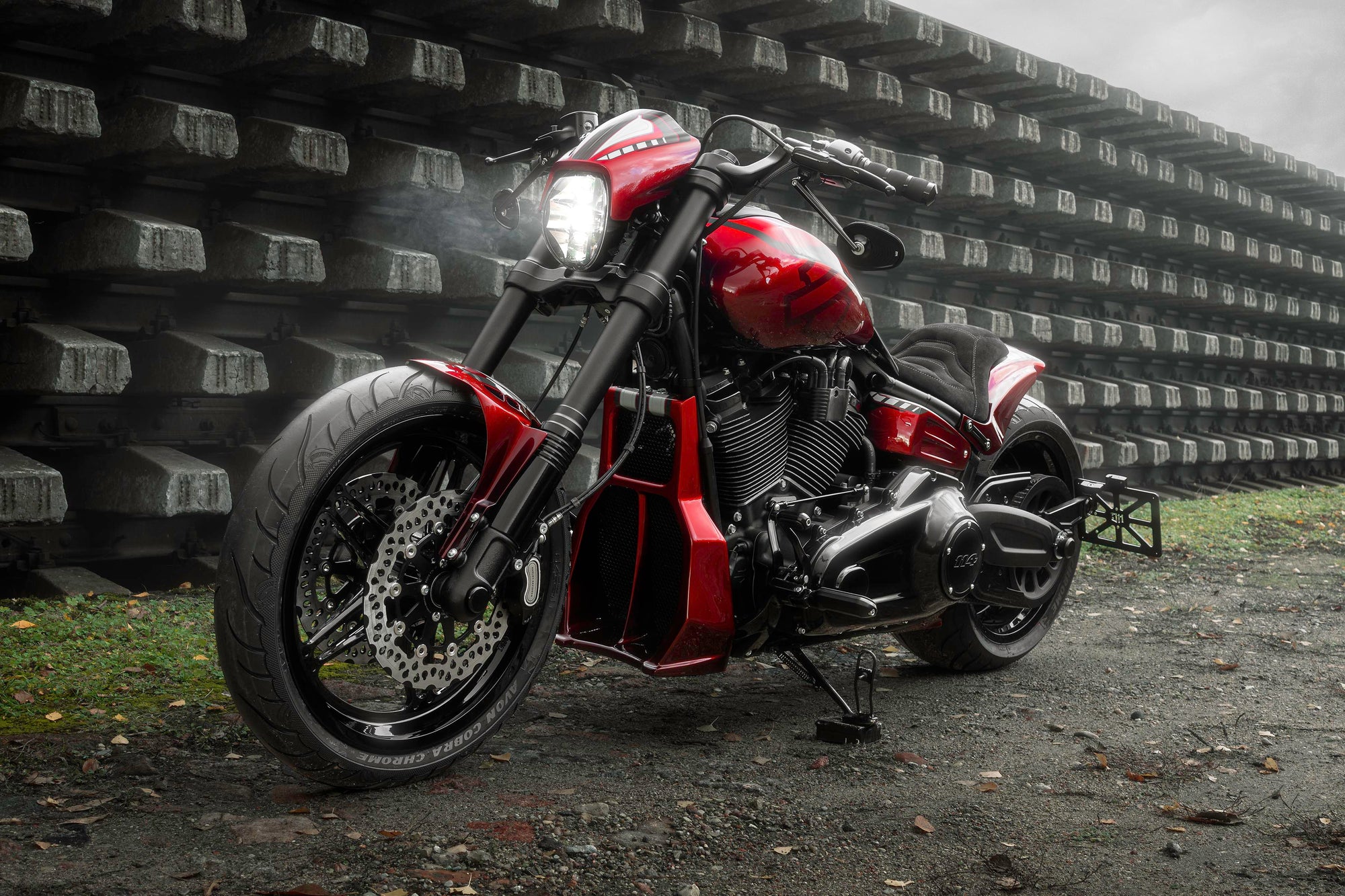 Modified Harley Davidson Softail motorcycle with Killer Custom parts from the side outside on a gloomy day in an industrial environment