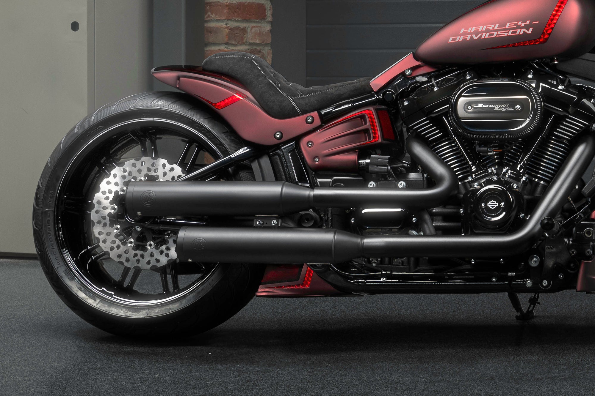 Zoomed Harley Davidson Breakout motorcycle with Killer Custom parts from the side in the garage