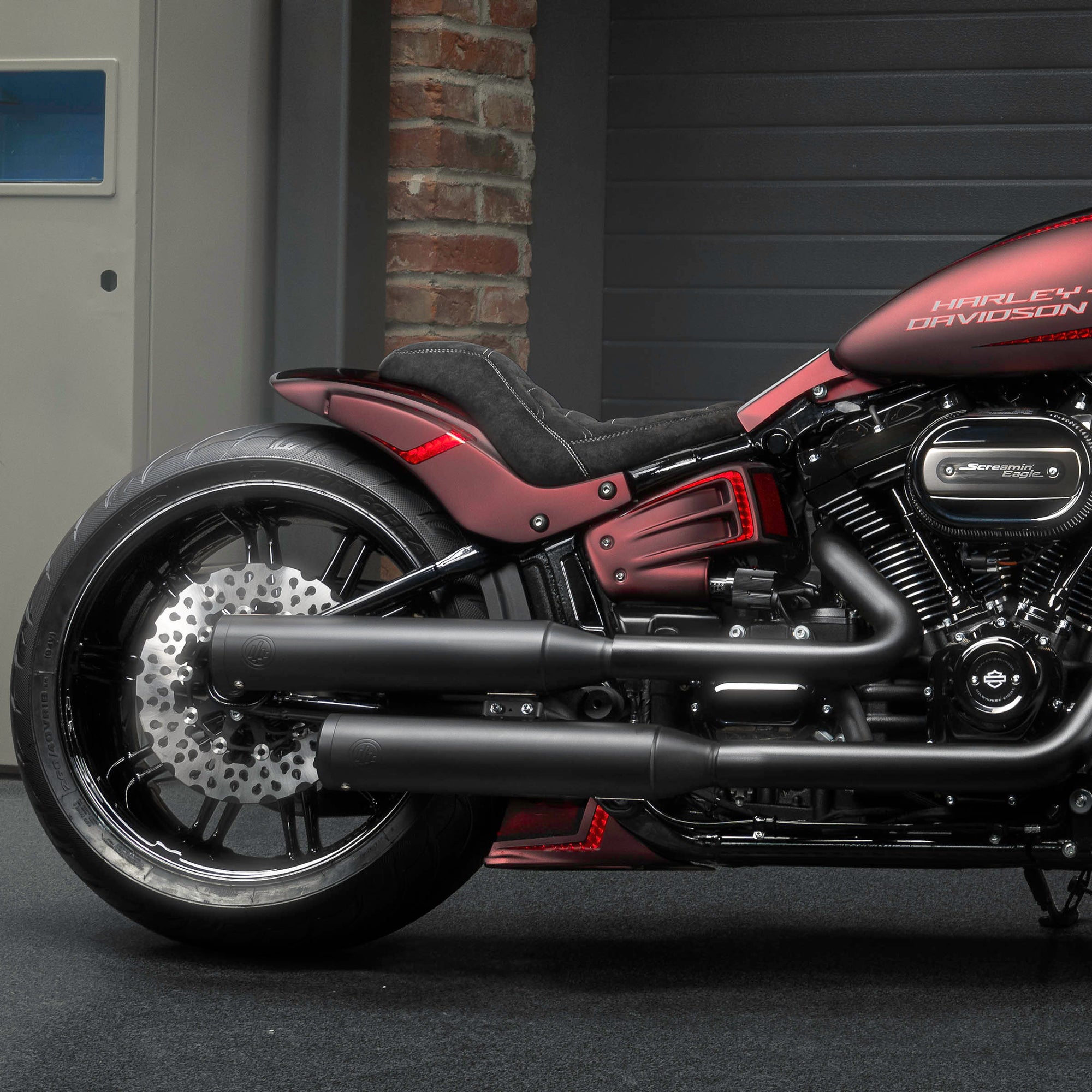 Zoomed Harley Davidson motorcycle with Killer Custom parts from the side in a modern garage
