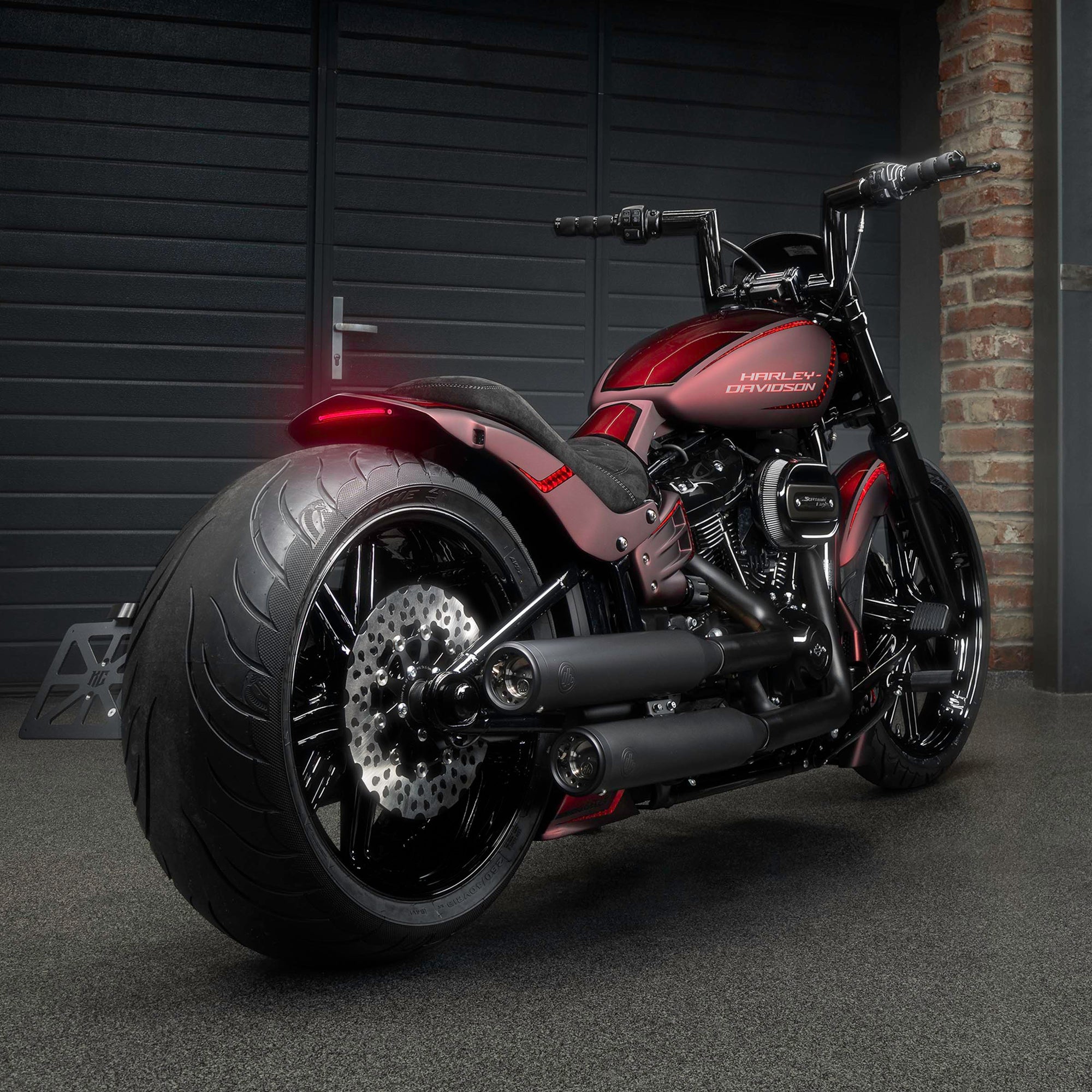 Harley Davidson motorcycle with Killer Custom parts from the rear in a modern garage