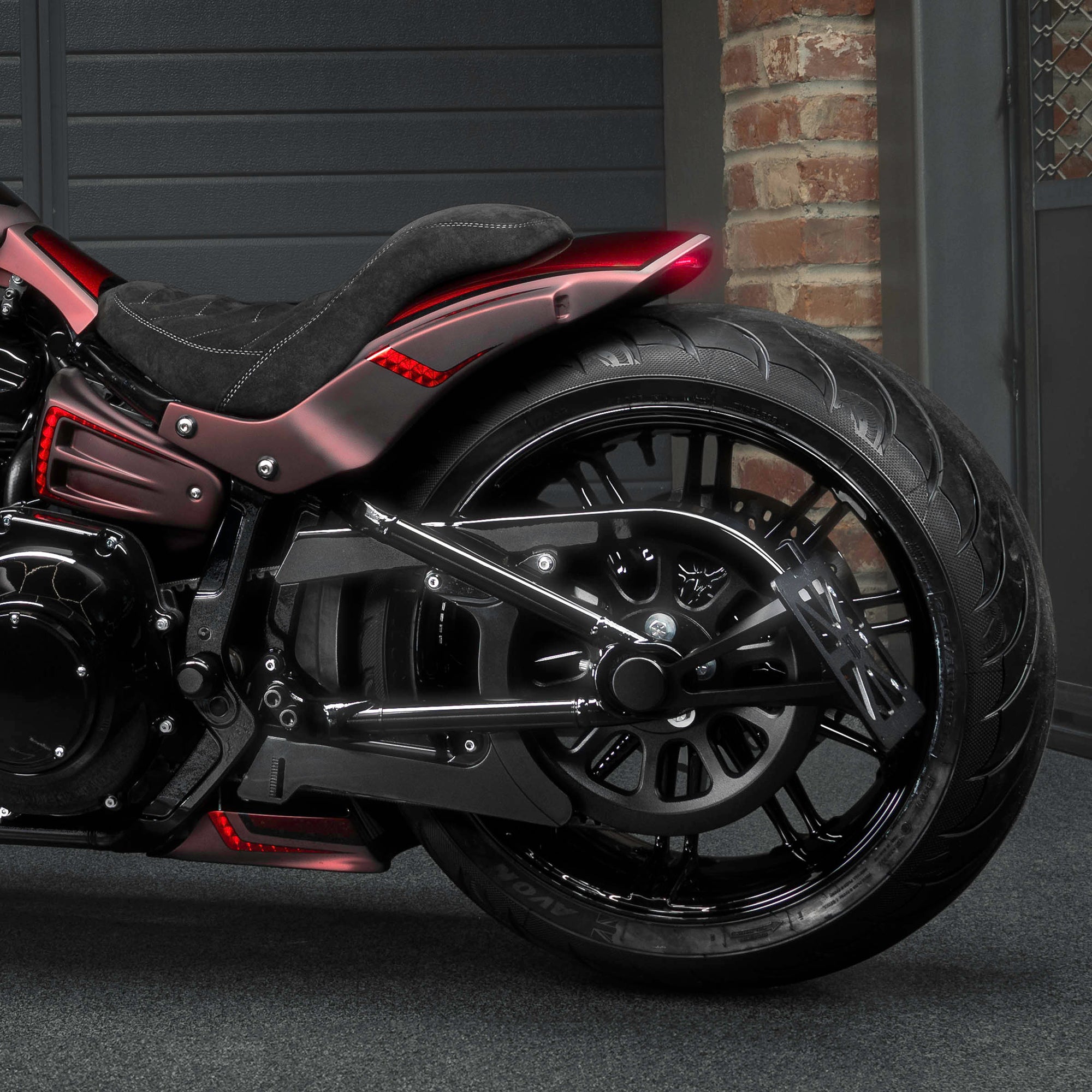 Zoomed Harley Davidson Breakout motorcycle with Killer Custom parts from the side in a modern garage