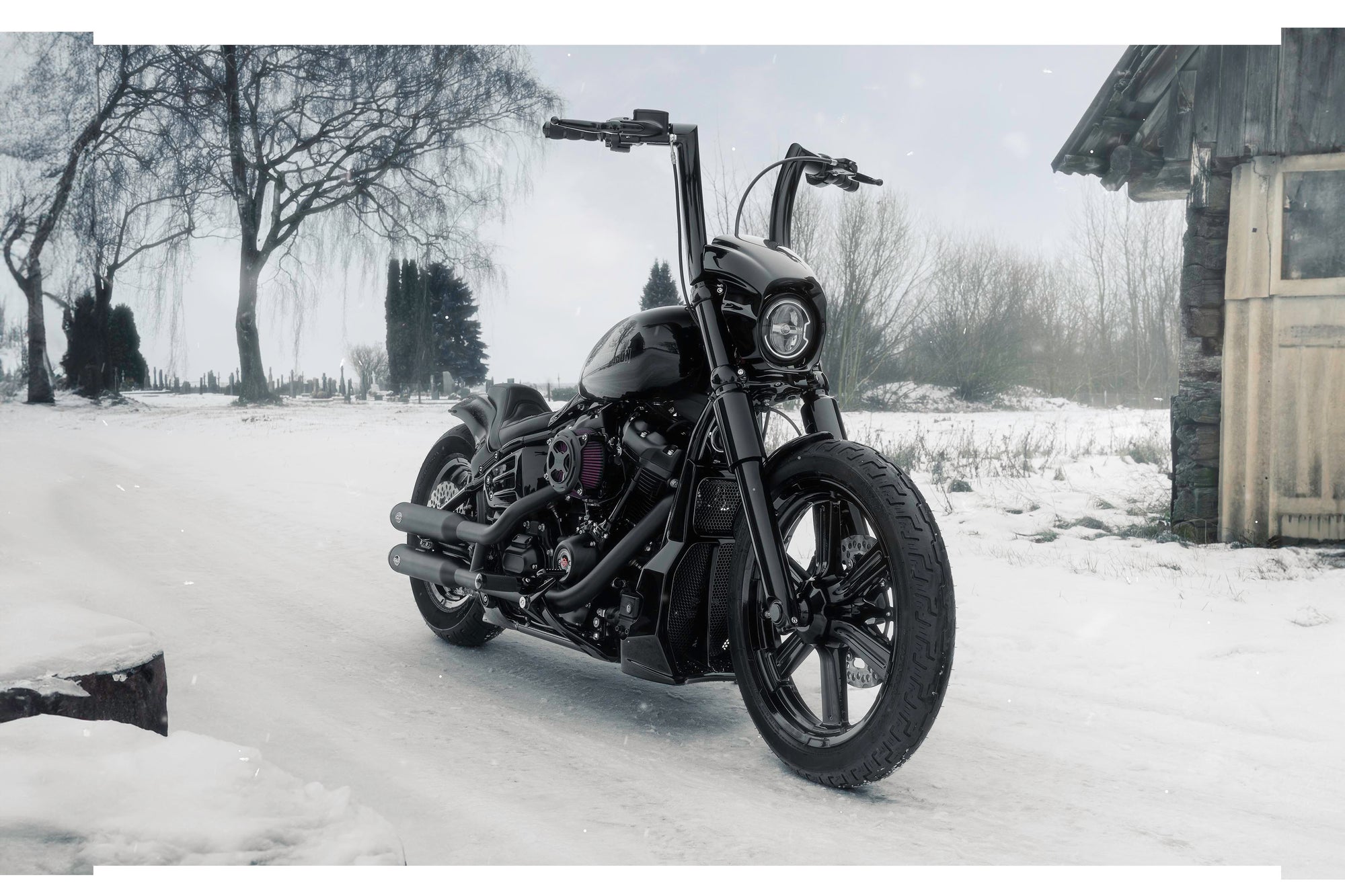 Harley Davidson motorcycle with Killer Custom parts form the front outside on a snowy day with an abandoned shack in the background