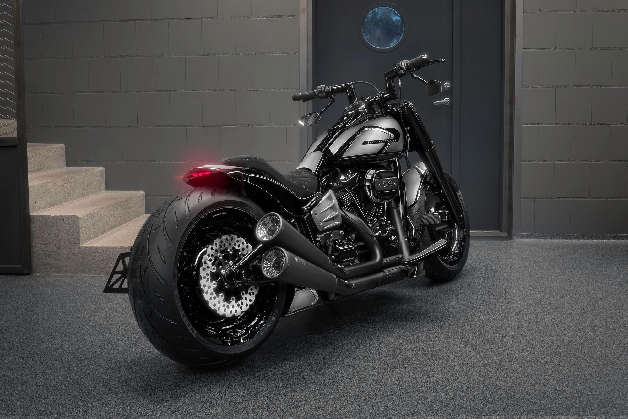 Modified Harley Davidson Softail Fat Boy motorcycle with Killer Custom parts from the rear in a modern bike shop
