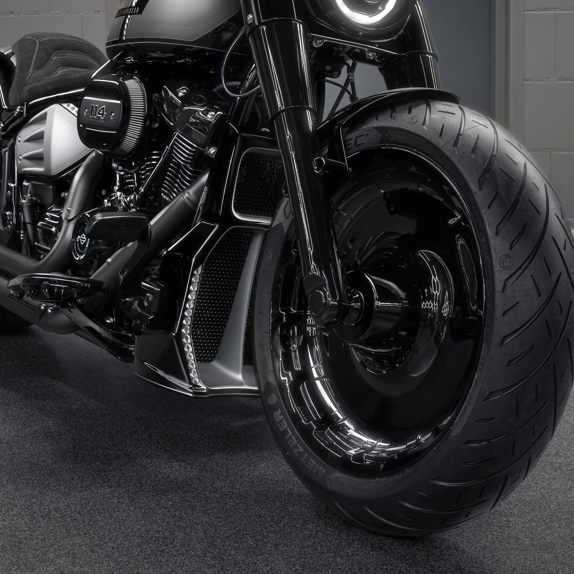 Zoomed Harley Davidson motorcycle with Killer Custom parts from the front in a modern bike shop