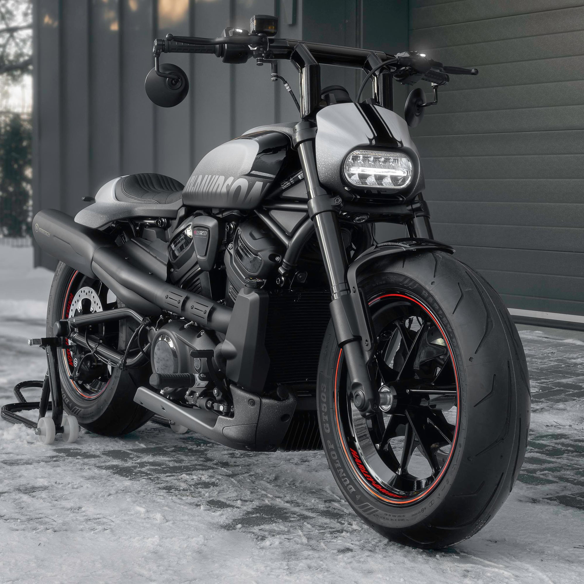 Harley Davidson motorcycle with Killer Custom parts from the front outside with some visible snow and a modern garage in the background