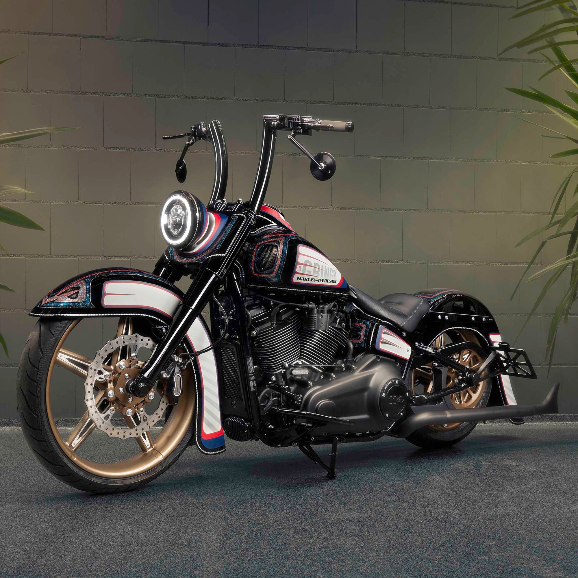 Modified Harley Davidson Heritage motorcycle with Killer Custom parts from the side grey brick wall in the background