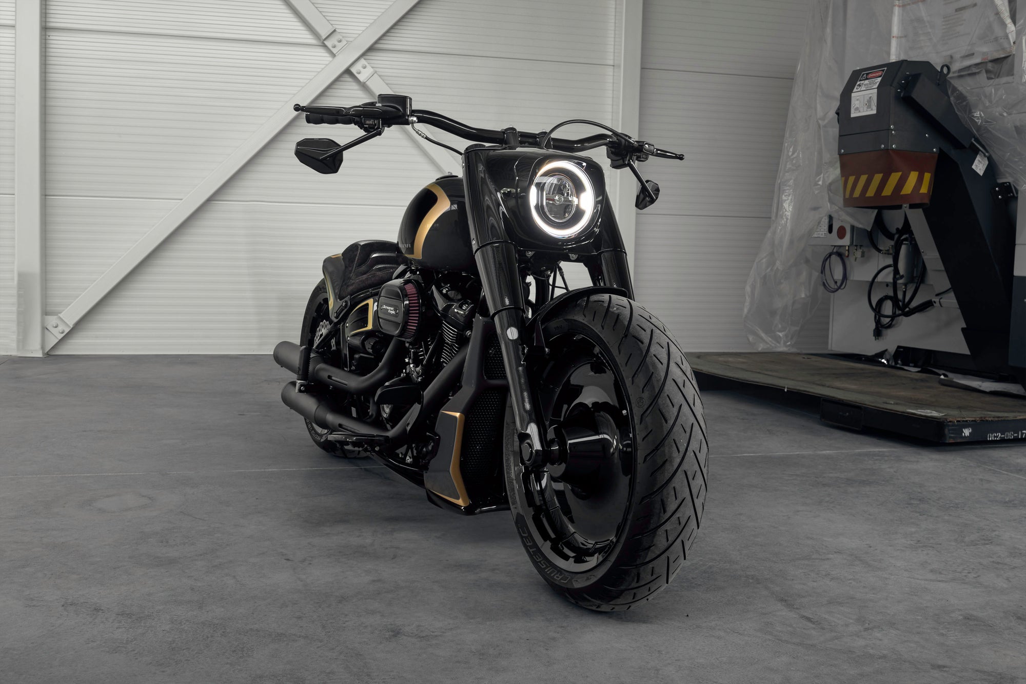 Modified Harley Davidson Fat Boy motorcycle with Killer Custom parts from the front in a modern garage