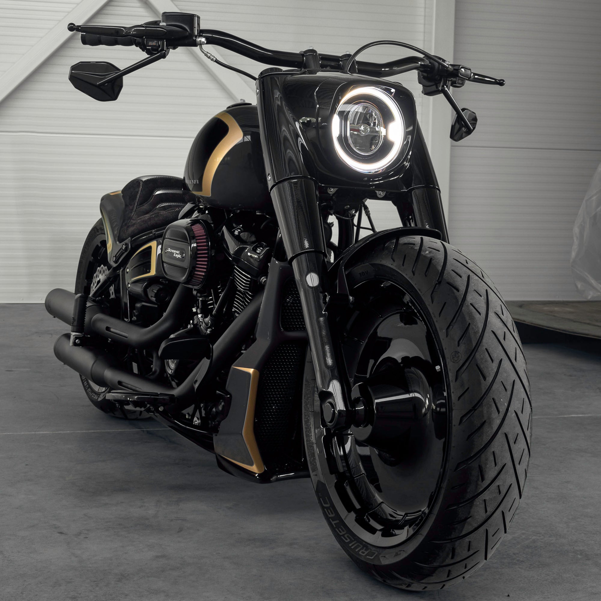 Harley Davidson motorcycle with Killer Custom parts from the front in a modern garage