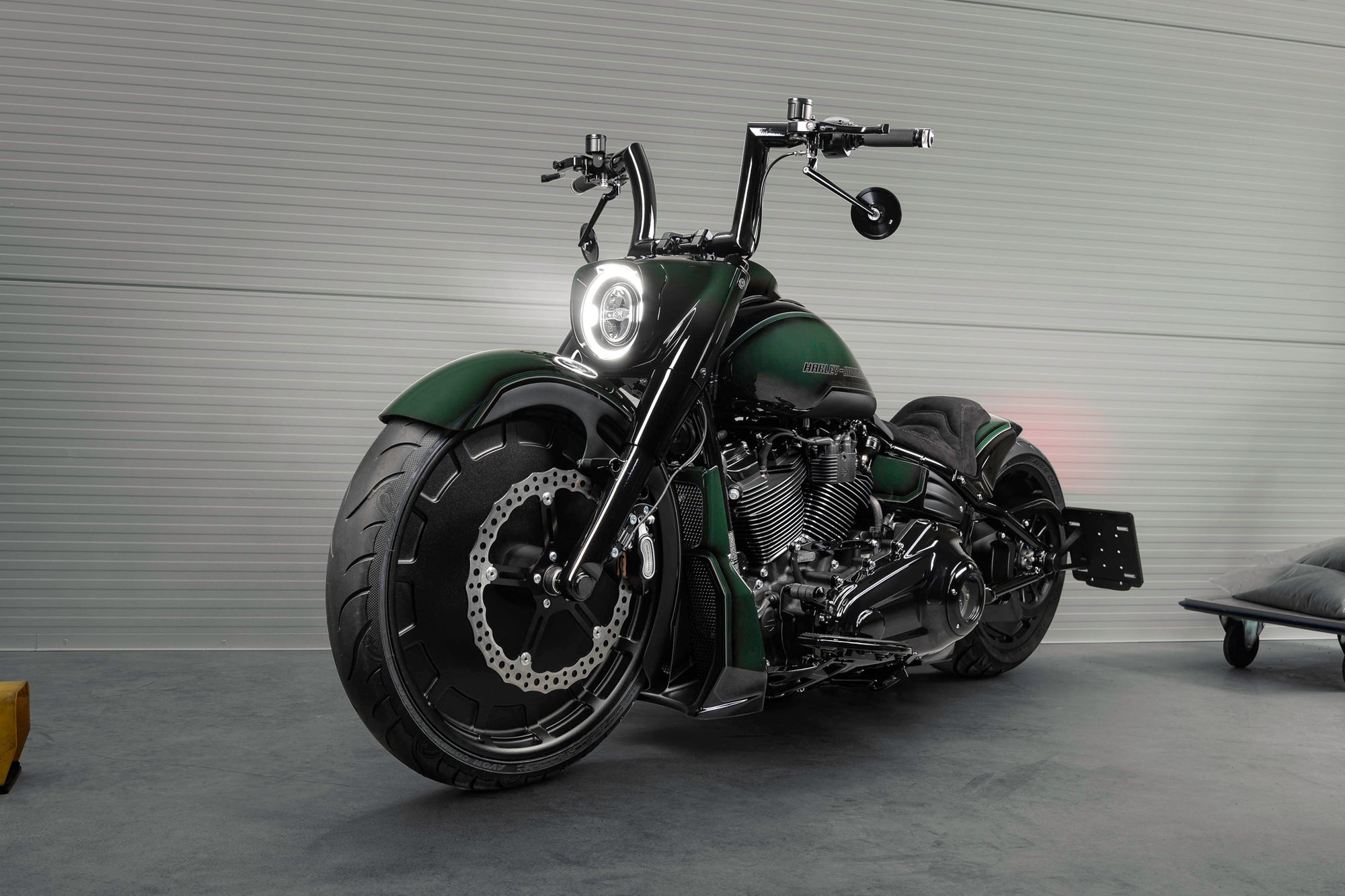 Modified Harley Davidson Fat Boy motorcycle with Killer Custom parts from the side in a spacious and modern garage