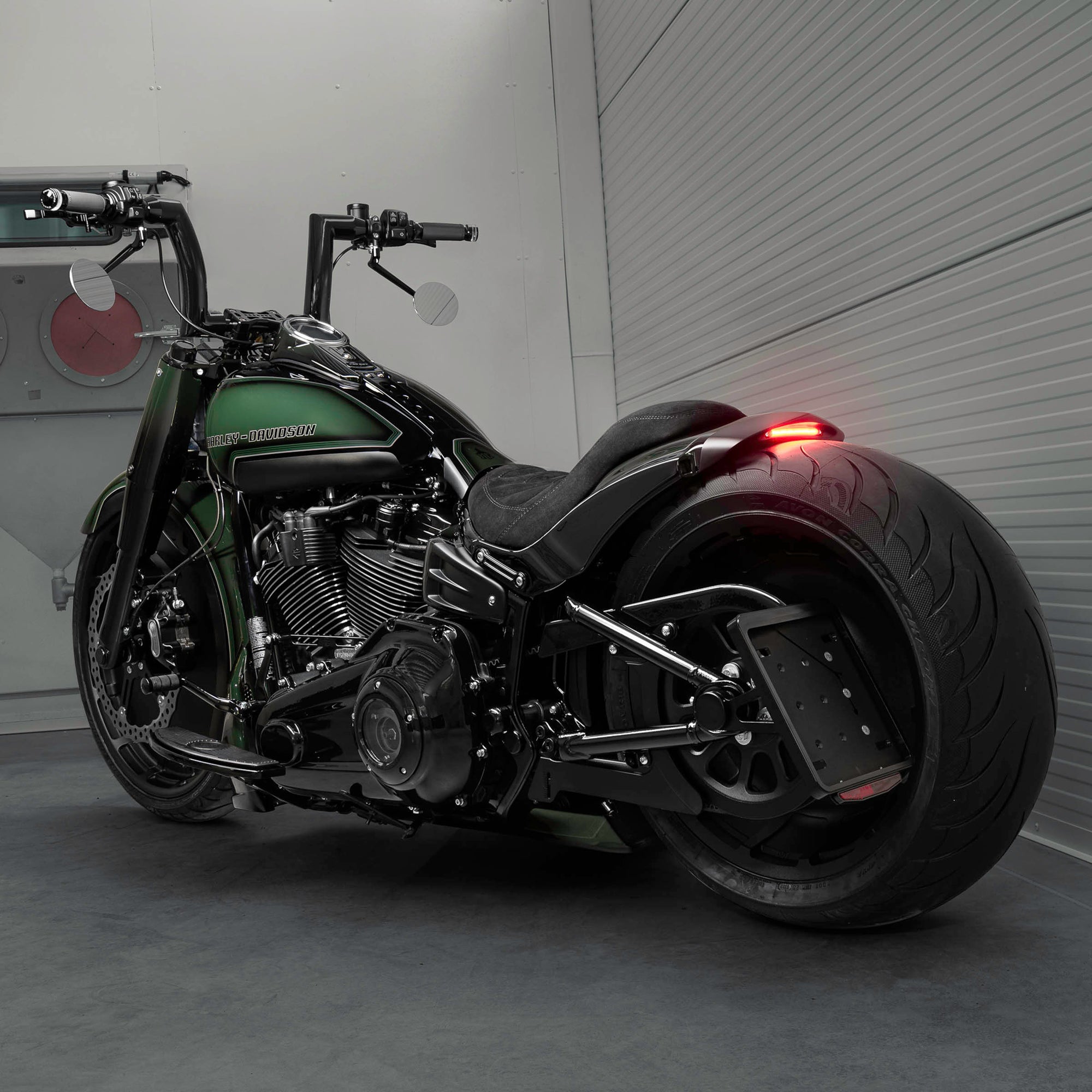 Harley Davidson motorcycle with Killer Custom parts from the rear in a spacious and modern garage