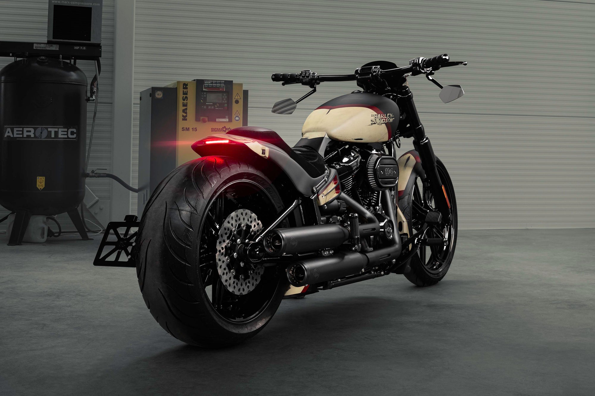Modified Harley Davidson Breakout motorcycle with Killer Custom parts from the rear in a modern bike shop