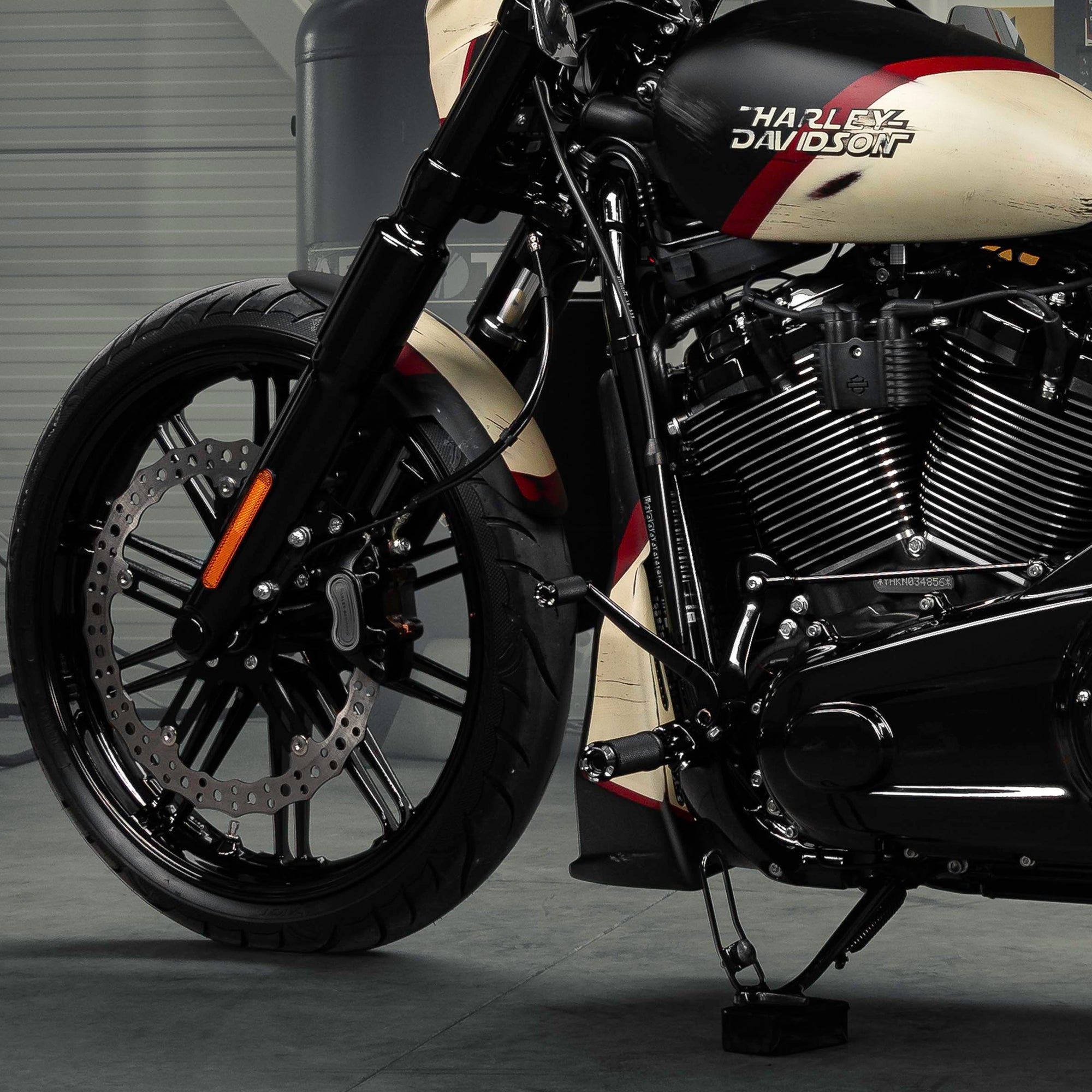 Zoomed Harley Davidson Breakout motorcycle with Killer Custom parts from the side in a modern bike shop