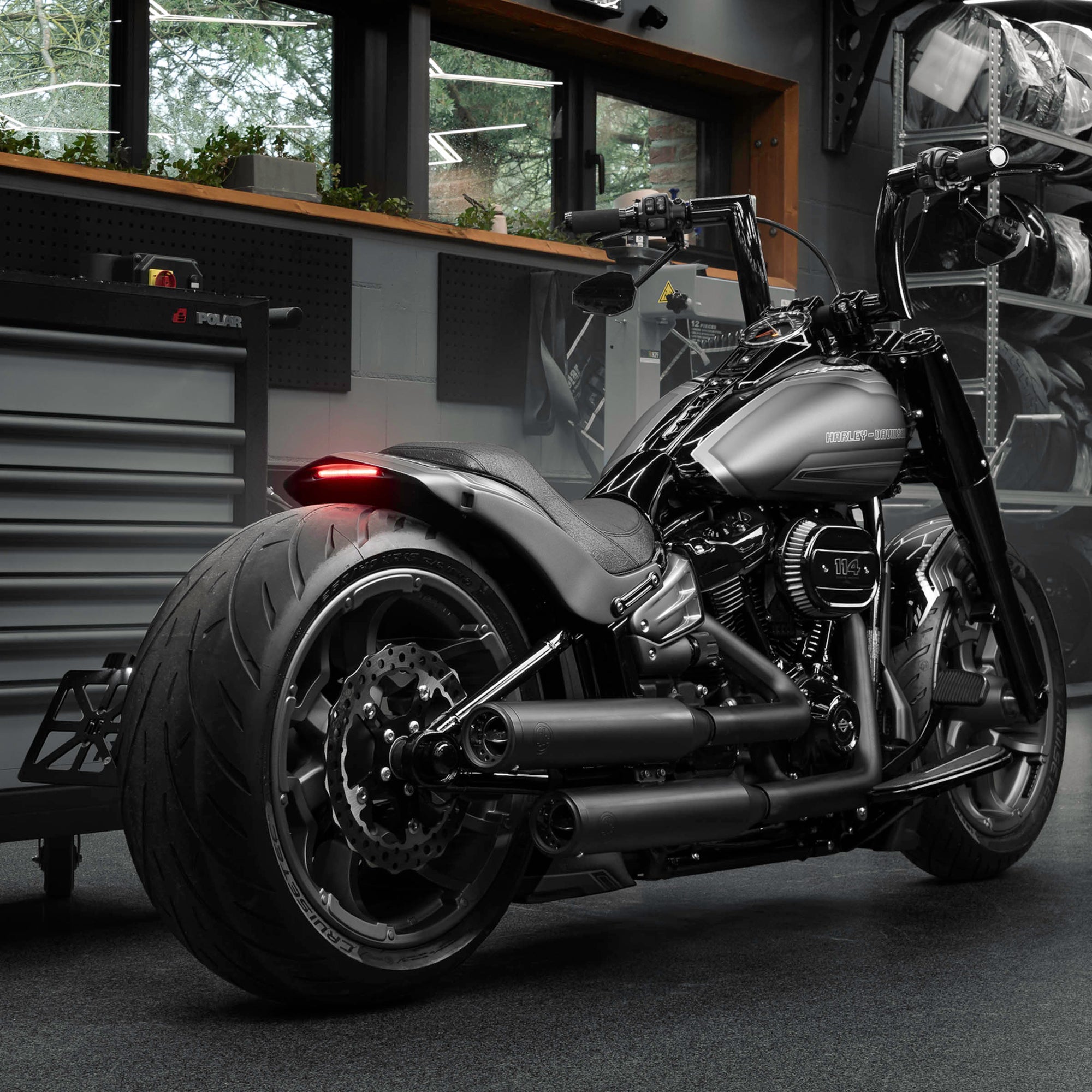 Modified Harley Davidson Fat Boy motorcycle with Killer Custom parts from the rear in a modern bike shop