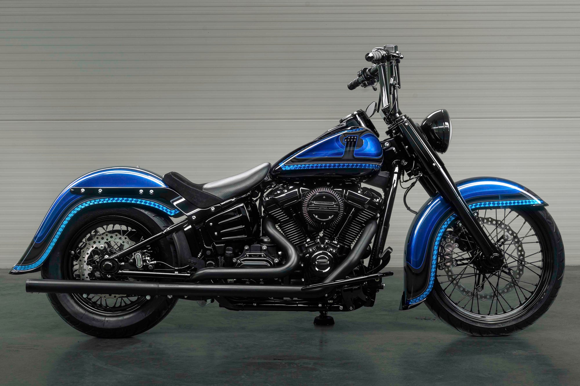 Harley Davidson motorcycle with Killer Custom parts from the side with a white wall in the background