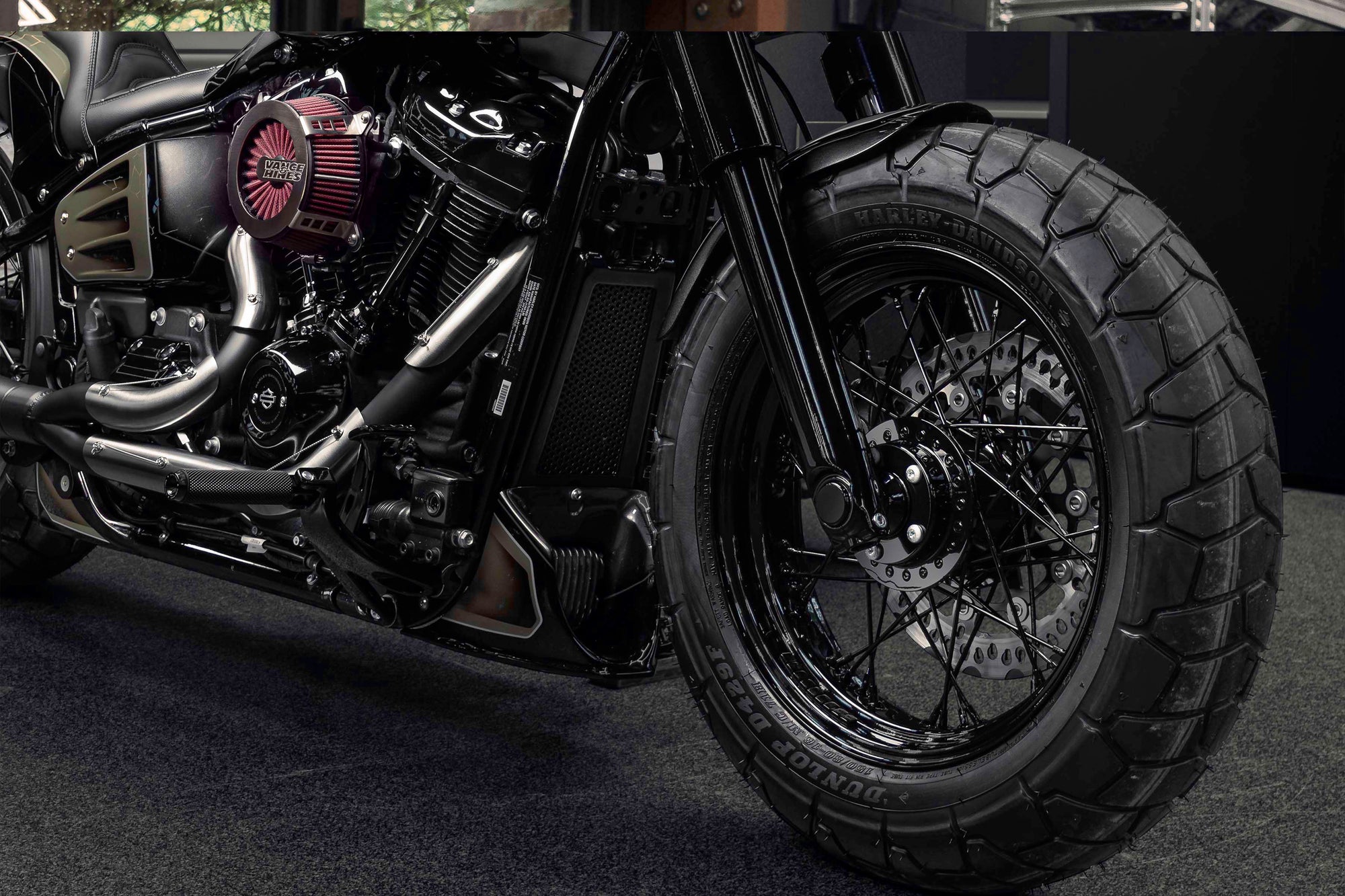 Zoomed Harley Davidson motorcycle with Killer Custom parts from the front in a modern bike shop