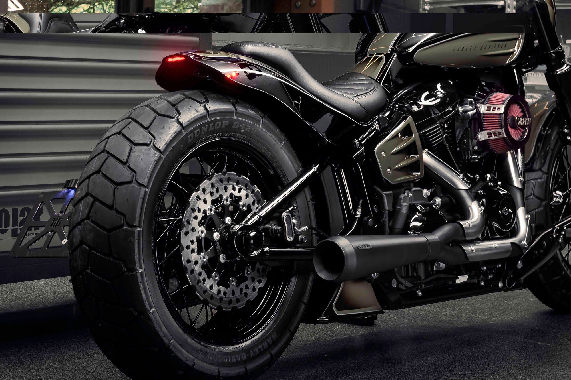 Zoomed Harley Davidson motorcycle with Killer Custom parts from the rear in a modern bike shop
