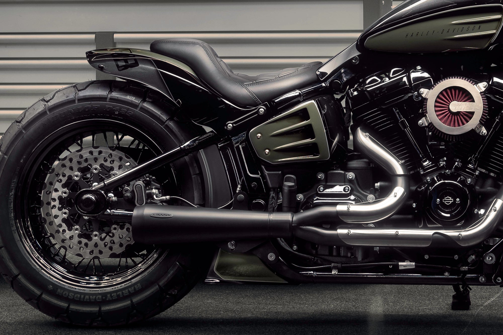 Modified Harley Davidson Street Bob motorcycle with Killer Custom parts from the side in a modern garage