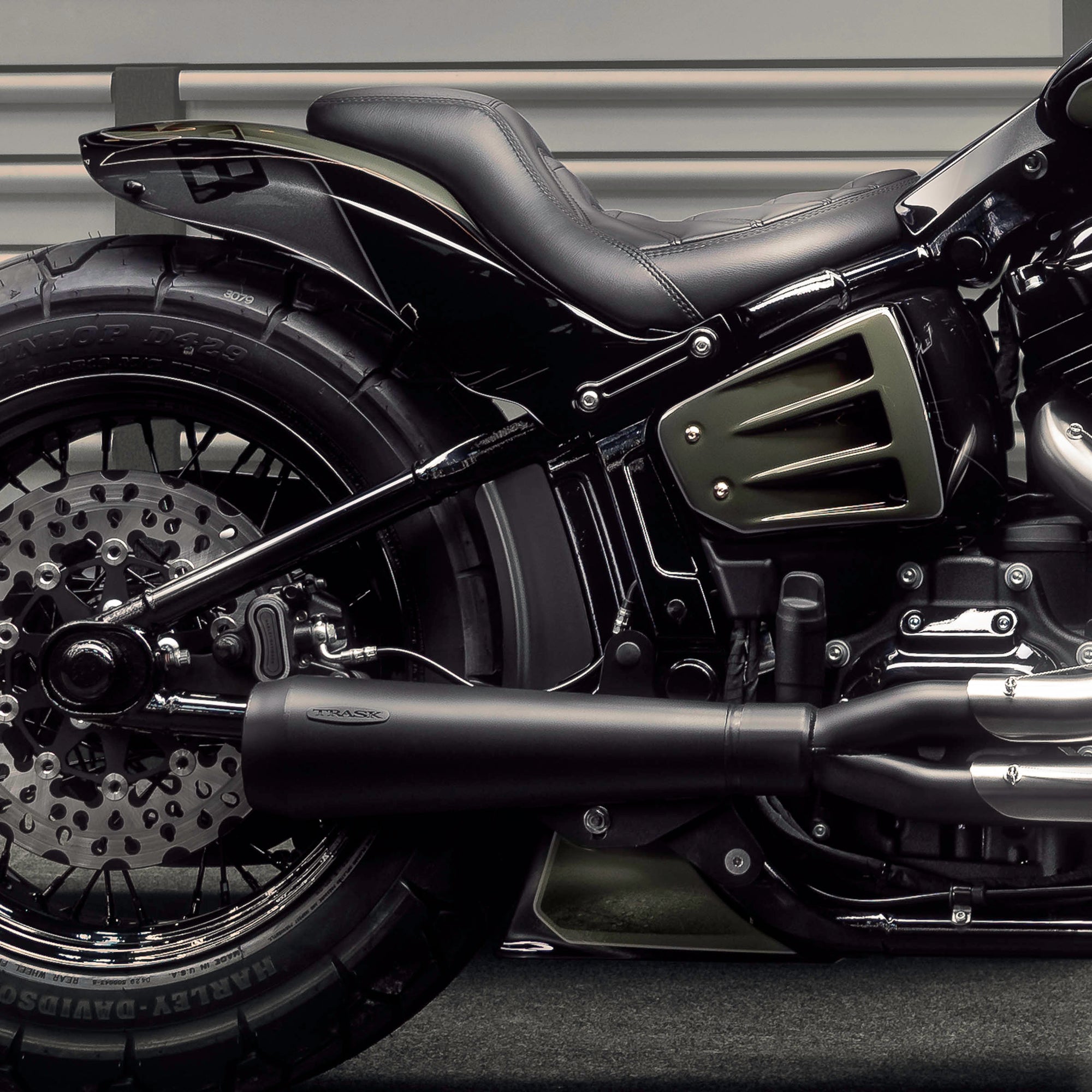 Zoomed and modified Harley Davidson Street Bob motorcycle with Killer Custom parts from the side in a modern garage