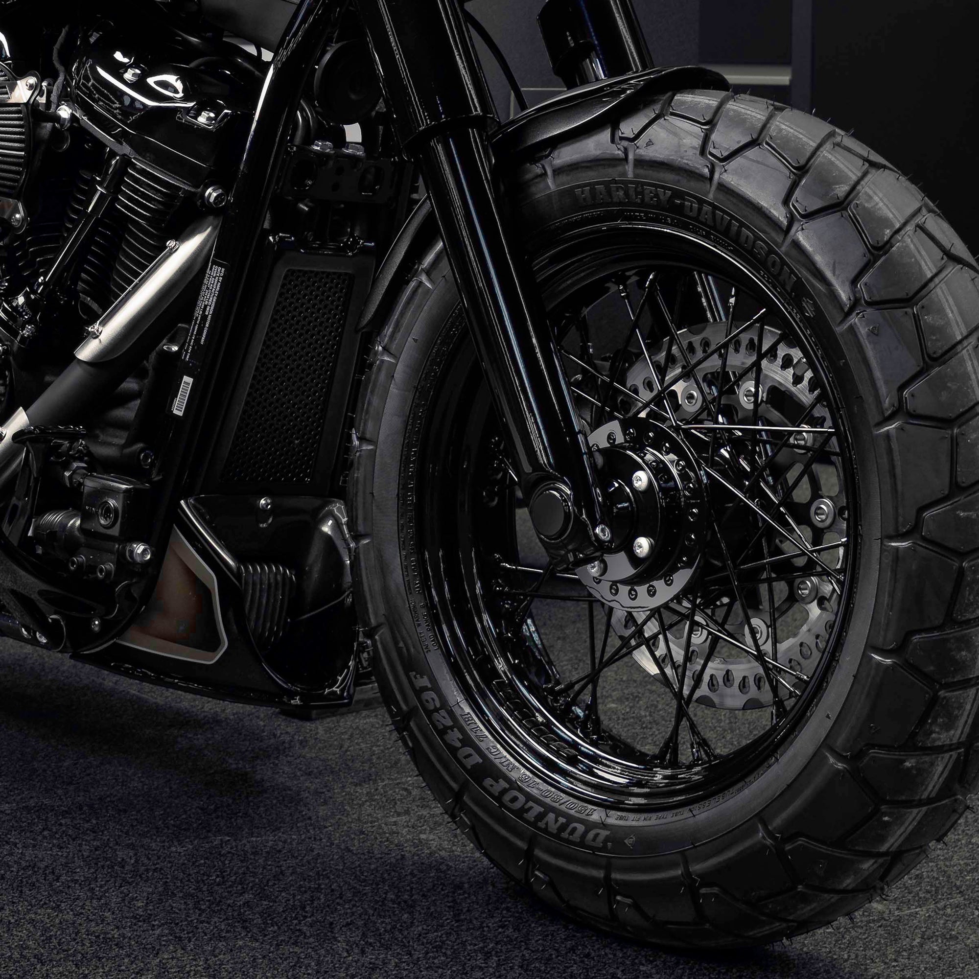 Zoomed Harley Davidson motorcycle with Killer Custom parts from the front grey background