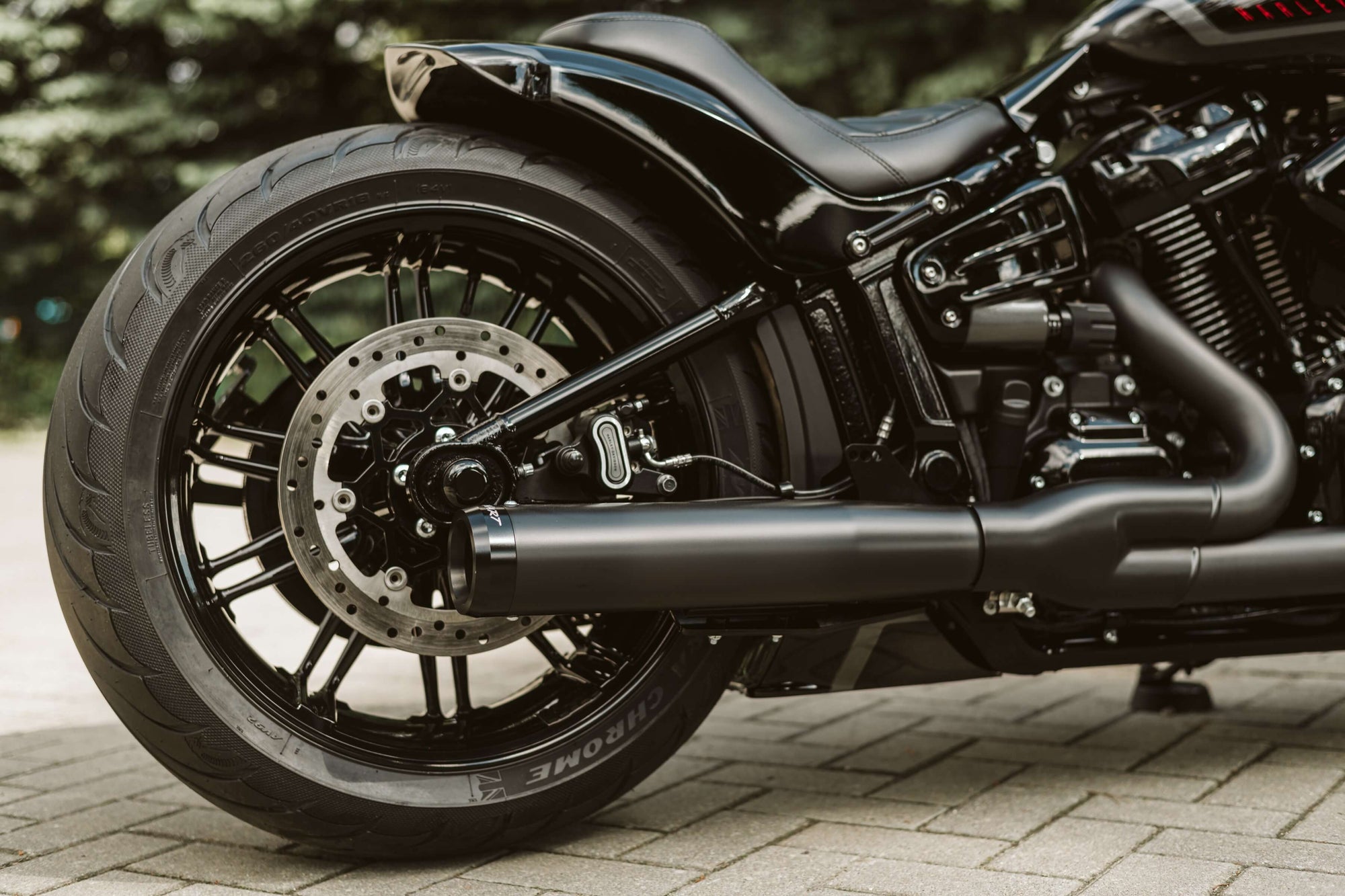Zoomed Harley Davidson motorcycle with Killer Custom parts from the side blurred nature background