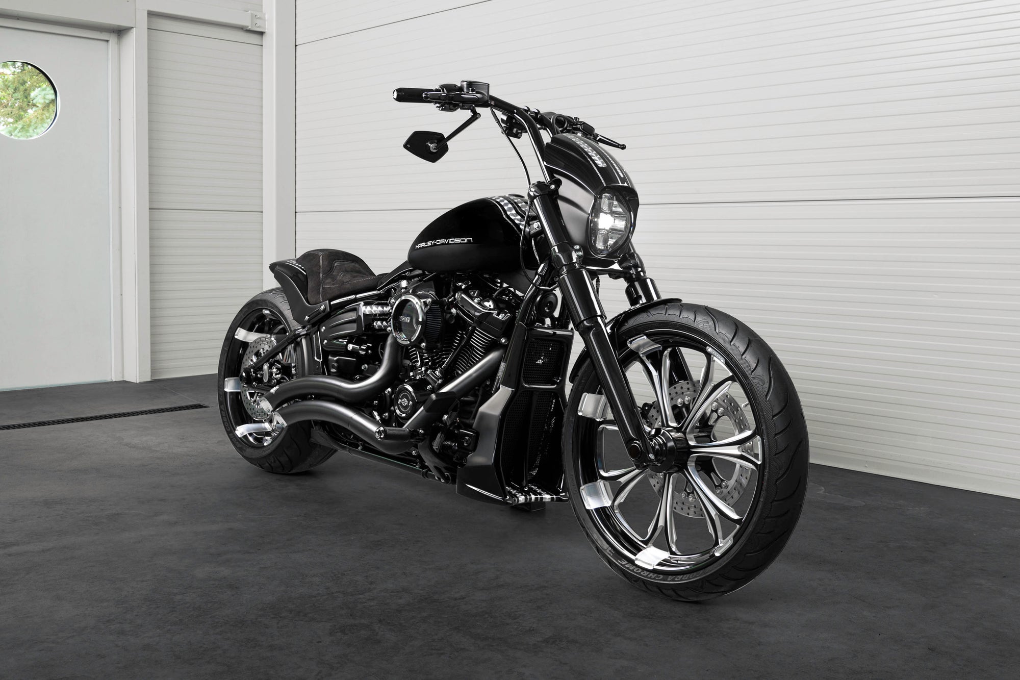 Harley Davidson motorcycle with Killer Custom parts from the front in a white modern bike shop